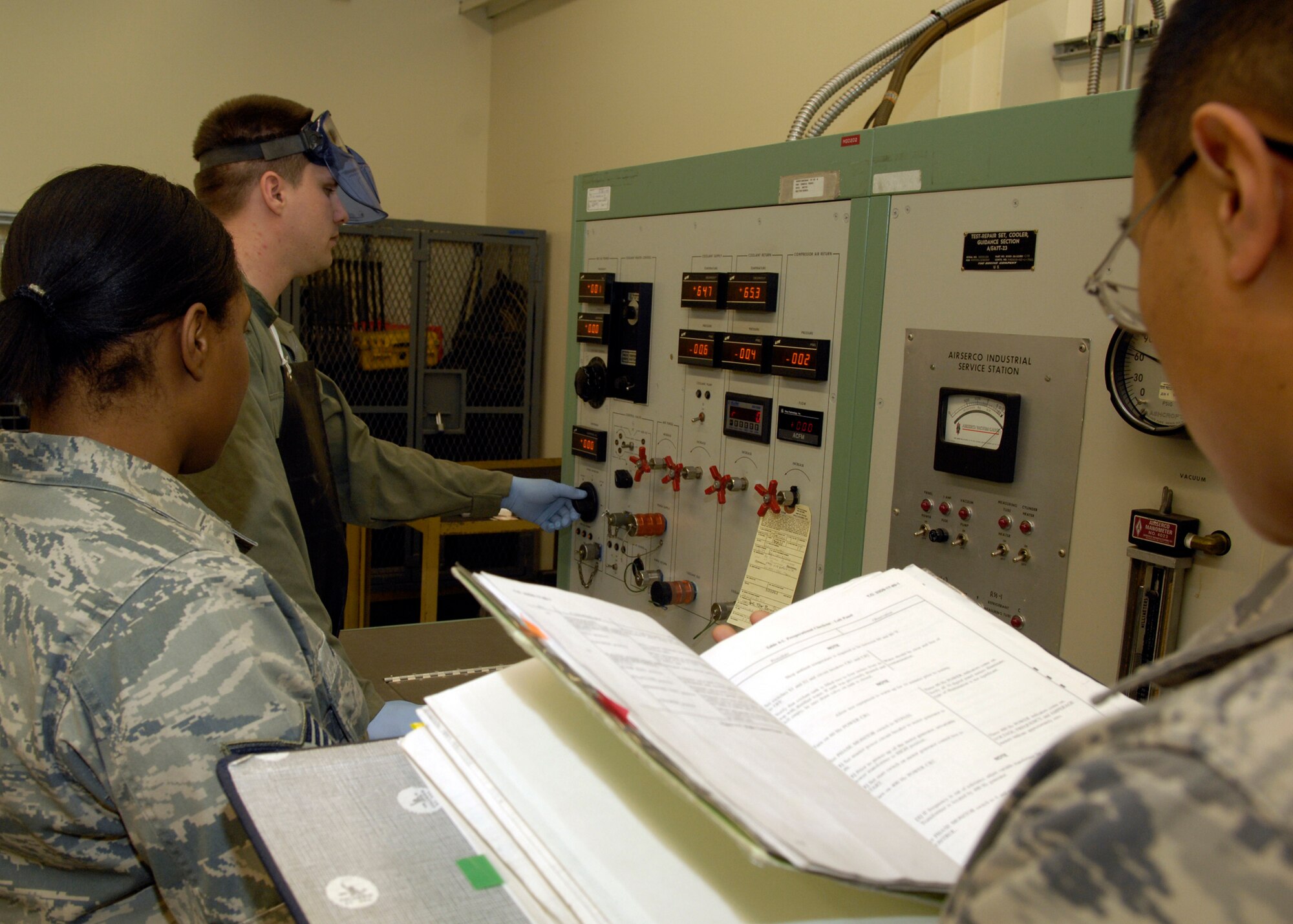 VANDENBERG AIR FORCE BASE, Calif. -- Staff Sgt. Randy Nepomuceno uses a technical order to guide Staff Sgts. Patricia Brown and Anthony Klatt through the preliminary checklist for the evaluation of the guidance and control test bench here Thursday, March 11, 2010. In order to ensure excellence in their maintenance, the facility maintainer's always need to have the correct TO read to them, word for word, while utilizing the testing equipment for any procedure. All three sergeants are with the 576th Flight Test Squadron. (U.S. Air Force photo/Airman 1st Class Lael Huss)