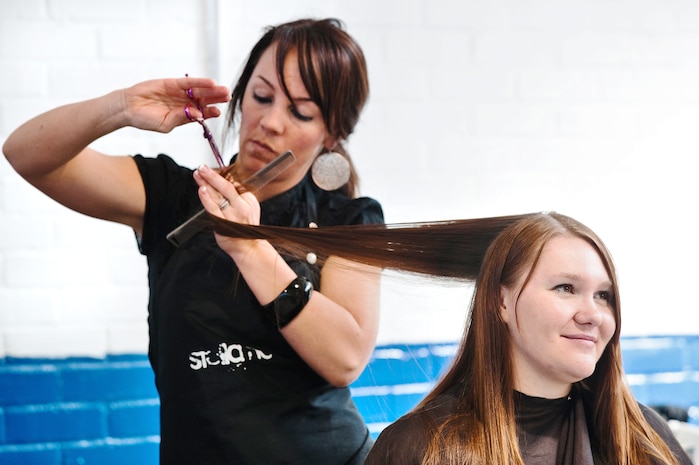 Jessica Fishel, an Air Force wife whose husband is currently deployed to Afghanistan, receives a free haircut and updated hairstyle by Emily Judelsohn, a Stella Nova hair stylist. Stella Nova hair and makeup artists pampered military wives as part of ?Makeovers for Military Wives,? an event hosted by The Look for Success non-profit group. Stella Nova beauty salon provided free hair cuts and beauty makeovers to more than 50 military wives. (U.S. Navy photo/Mass Communicator 3rd Class Juan Pinalez)