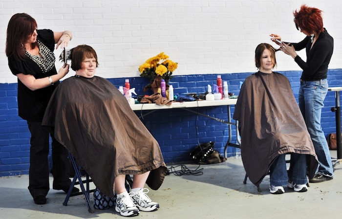 Navy wife, Cindy Barker, left, and Army wife, Emily Cosimano, right, receive free hair cuts from Stella Nova beauty salon hair stylists March 27, 2010, at Armory Park in North Charleston, S.C. Stella Nova hair and makeup artists pampered military wives as part of ?Makeovers for Military Wives,? an event hosted by The Look for Success non-profit group. The wives were also treated to a visit from four cast members of the "Army Wives" television show. (U.S. Navy photo/Mass Communicator 3rd Class Juan Pinalez)