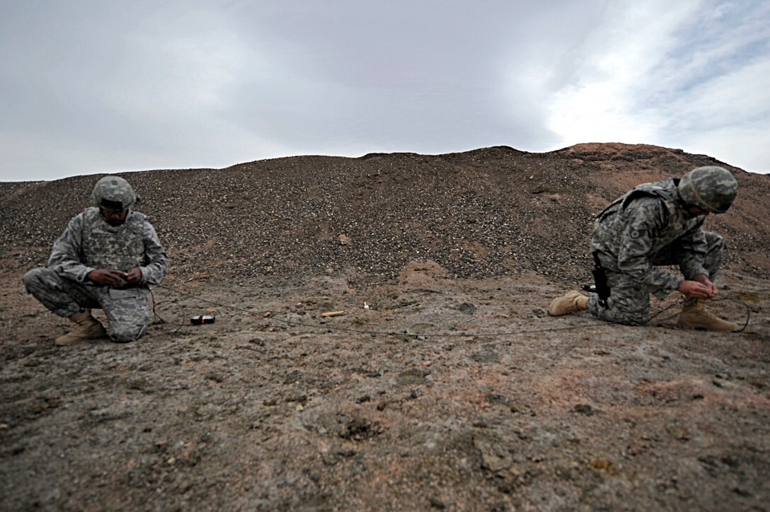 ELLSWORTH AIR FORCE BASE, S.D. -- (Left to right) Master Sgt. Anthony Blackmon, 28th Civil Engineer Squadron explosive ordnance disposal flight chief, and Staff Sgt. Darryl Wilcken, 28 CES EOD journeyman, tie detonation cords together during a training exercise, March 30. The training was designed to demonstrate proper procedures when disposing of various explosive ordnances. (U.S. Air Force photo/Airman 1st Class Matthew Flynn)