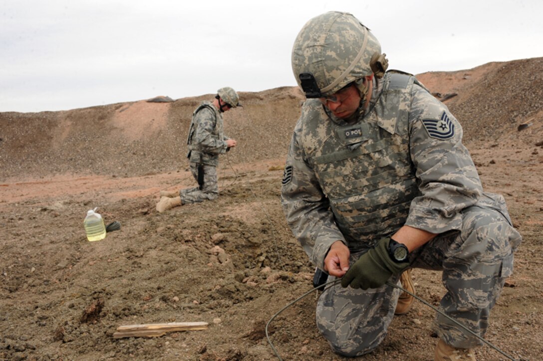 ELLSWORTH AIR FORCE BASE, S.D. — Tech. Sgt. Jayson Wells, 28th Civil Engineer Squadron explosive ordnance disposal journeyman, sets the main line for a shaped charge explosion, March 30. The main line sets the charge and others control the fuel burn leading to the explosive. (U.S. Air Force photo/Senior Airman Adam Grant)   