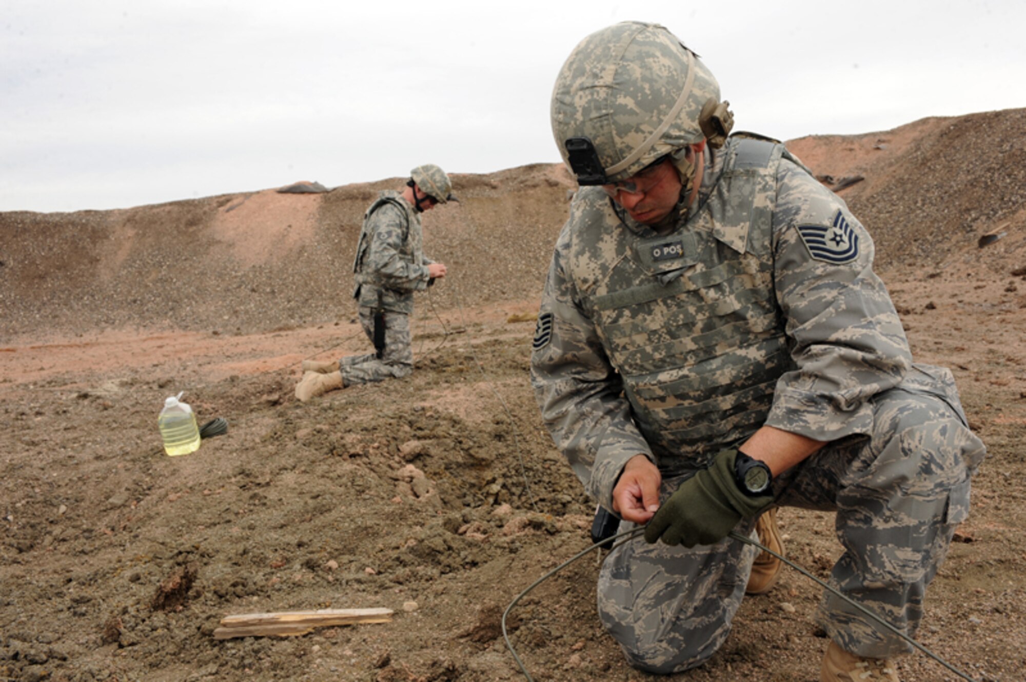 ELLSWORTH AIR FORCE BASE, S.D. — Tech. Sgt. Jayson Wells, 28th Civil Engineer Squadron explosive ordnance disposal journeyman, sets the main line for a shaped charge explosion, March 30. The main line sets the charge and others control the fuel burn leading to the explosive. (U.S. Air Force photo/Senior Airman Adam Grant)   