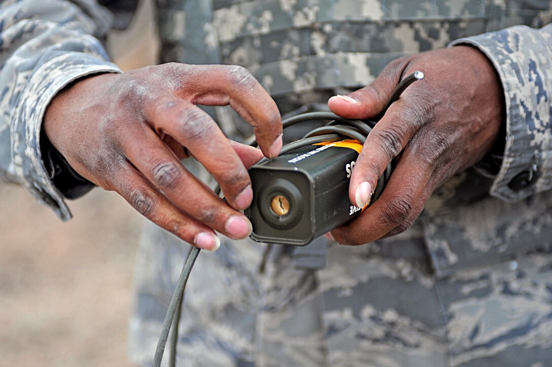ELLSWORTH AIR FORCE BASE, S.D. -- Master Sgt. Anthony Blackmon, 28th Civil Engineer Squadron explosive ordnance disposal flight chief, wraps detonation cord around TNT, March 30. EOD personnel routinely train on various controlled explosions using TNT, dynamite and C4 to maintain combat readiness. (U.S. Air Force photo/Airman 1st Class Matthew Flynn)
