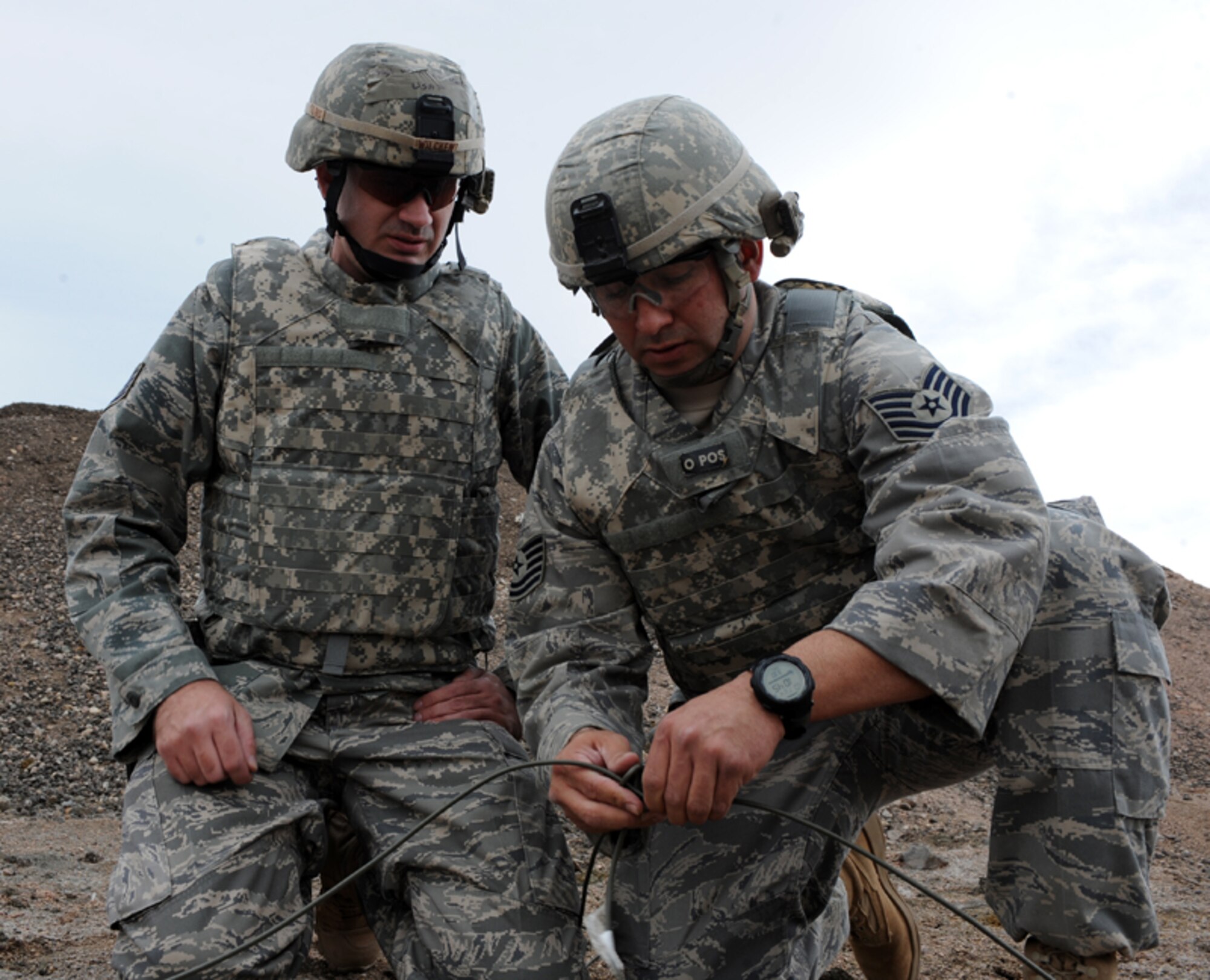 ELLSWORTH AIR FORCE BASE, S.D. — (Left) Staff Sgt. Darryl Wilcken, 28th Civil Engineer Squadron explosive ordnance disposal journeyman, observes as (right) Tech. Sgt. Jayson Wells, 28th CES explosive ordnance disposal journeyman, ties a knot, March 30. The knots are branched from the main line which, once triggered, will set off a shaped charge. (U.S. Air Force photo/Senior Airman Adam Grant)   
