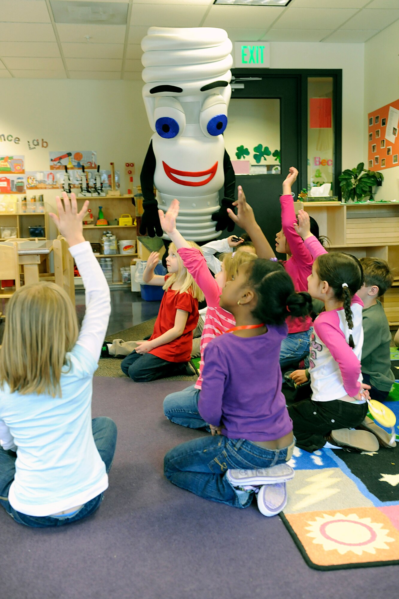 PETERSON AIR FORCE BASE, Colo. -- Children at the R.P. Lee Youth Center here offer ideas on how they can help save energy during a March 26 visit by the 21st Civil Engineer Squadron mascot “Pete Light.” Some children at the center have formed a “Don’t Trash the Planet” club and are sharing ideas about recycling and energy conservation. (U.S. Air Force photo/Larry Hulst) 