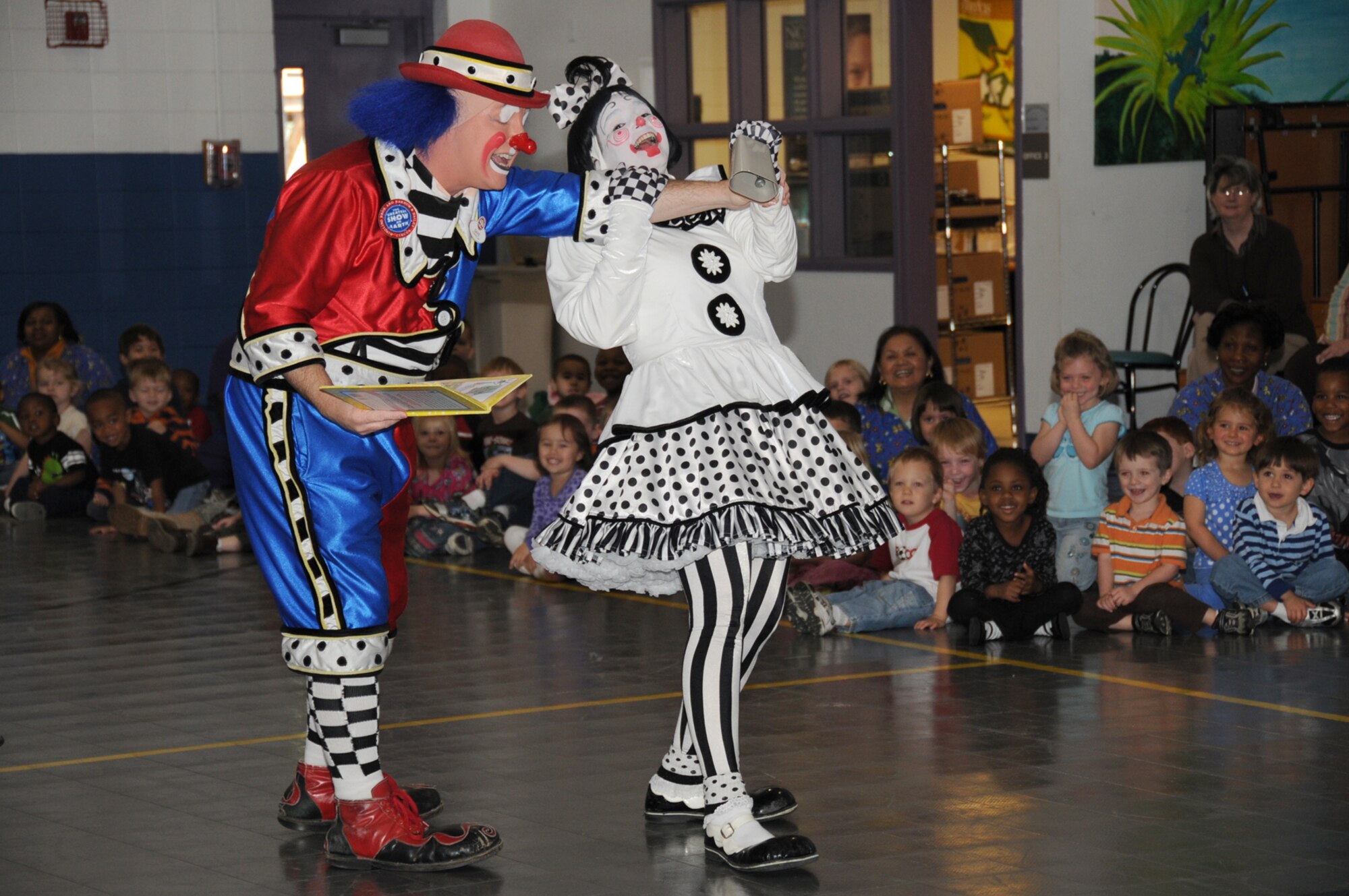 Clowns Dave and Cherie Gregg, “ambassadors of laughter” from the Ringling Brothers and Barnum & Bailey Circus, visited preschoolers from the child development center March 23 at the youth center gym.  The visit was part of the Reading with Ringling educational program for youngsters in preschool through third grade.  Dave and Cherie presented an animated demonstration and storytelling of “Maximilian the Great.”   (U.S. Air Force photo by Kemberly Groue)