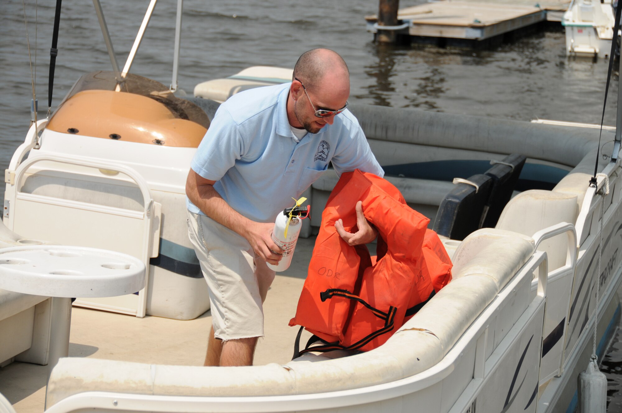 Joe Heflin from outdoor recreation checks safety gear on one of the marina’s rental pontoon boats.  (U.S. Air Force photo by Kemberly Groue)