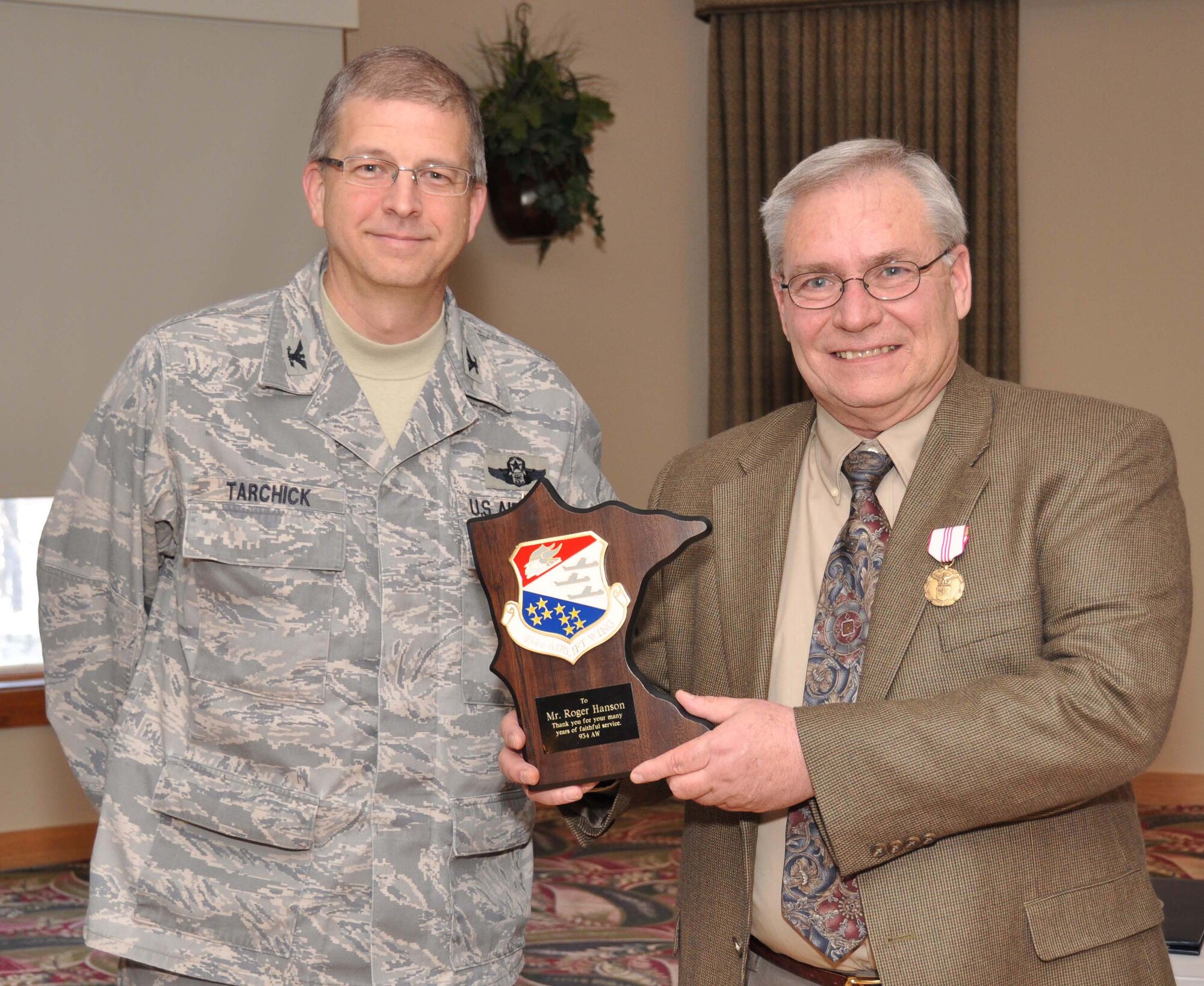 Roger Hanson, 934th Mission Support Group, receives his retirement plaque from Col. Tim Tarchick, 934th Airlift Wing commander, Feb. 25.  Hanson retired with more than 36 years Federal Civil Service. (Air Force Photo/Master Sgt. Paul Zadach)