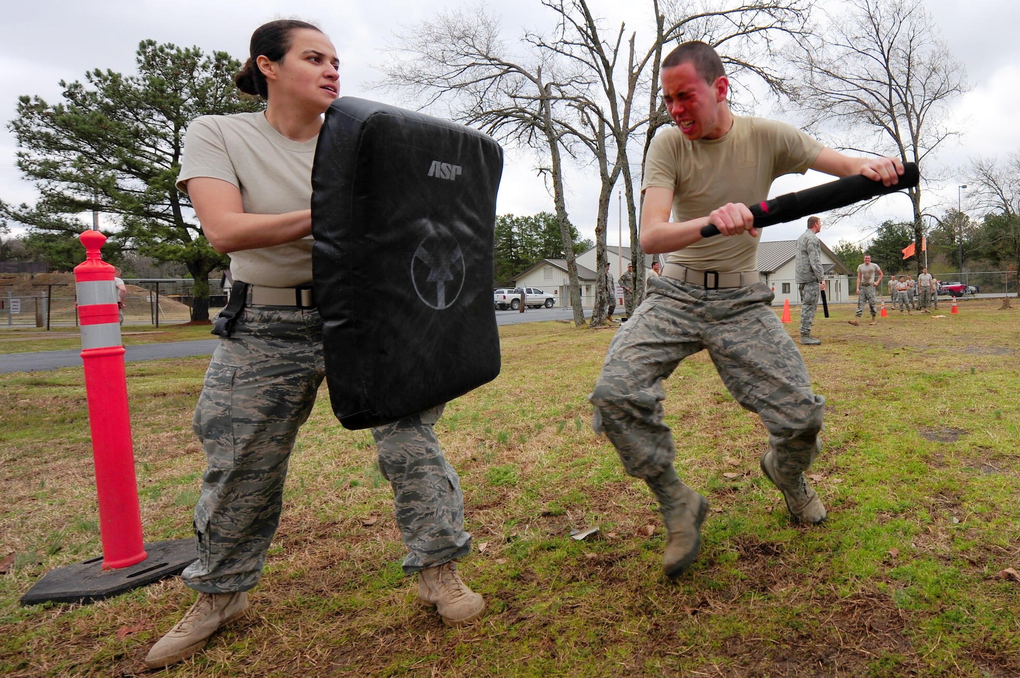 Airman 1st Class Leslie Medina, a 19th Security Forces Squadron patrolman, holds a barrier up to Airman 1st Class Brenden Campbell, a 19th SFS pepper spray trainee, as he prepares to strike during a training course March 25 at Camp Warlord. Security forces Airmen completed several self-defense tactics after being sprayed with 'OC' or Oleoresin Capsicum pepper spray. The training is a requirement to carry pepper spray while performing real-world duties. (U.S. Air Force photo by Senior Airman Steele C. G. Britton)