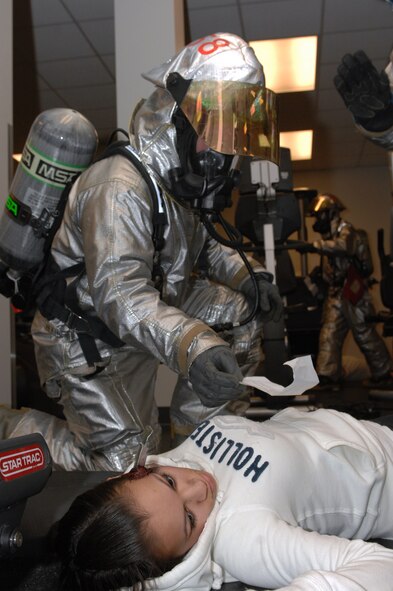 MINOT AIR FORCE BASE, N.D. – A fire fighter from the 5th Civil Engineer Squadron assists Airman 1st Class Summer Mancilla, 5th Maintenance Operations Squadron scheduler, during a major accident response exercise here March 26. Exercises like this provide the installation commander a way to conduct realistic exercises for all installation personnel. (U.S. Air Force photo by Airman 1st Class Aaron-Forrest Wainwright)