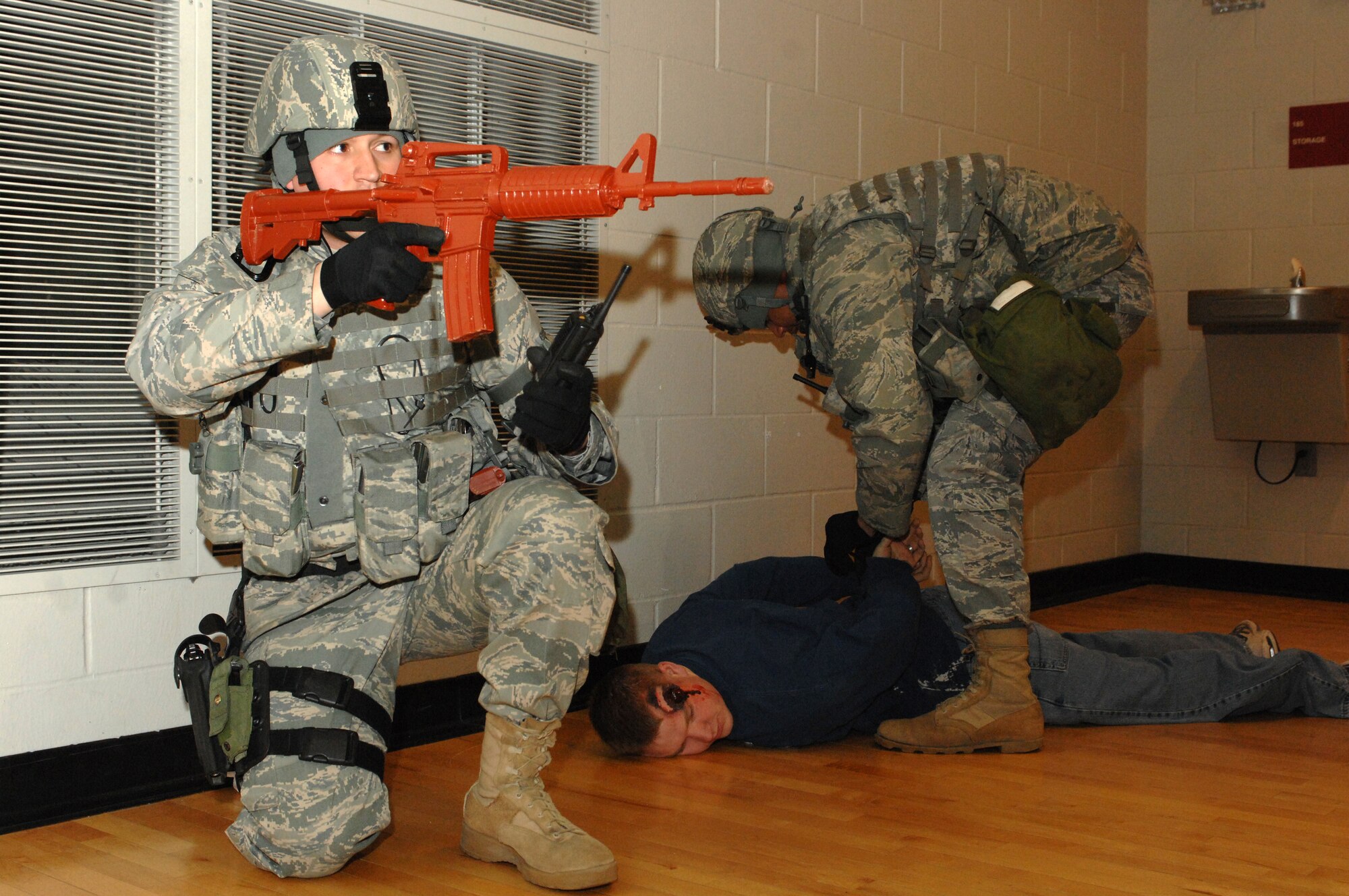 MINOT AIR FORCE BASE, N.D. -- Staff Sgt. Jarrod Nelson, 5th Security Forces Squadron fire team leader, provides security while another member of the team detains a possible shooter in the McAdoo Sports and Fitness Center during a major accident response exercise March 26. Exercises like this provide the installation commander a way to conduct realistic exercises for all installation personnel. (U.S. Air Force photo by Airman 1st Class Aaron-Forrest Wainwright)