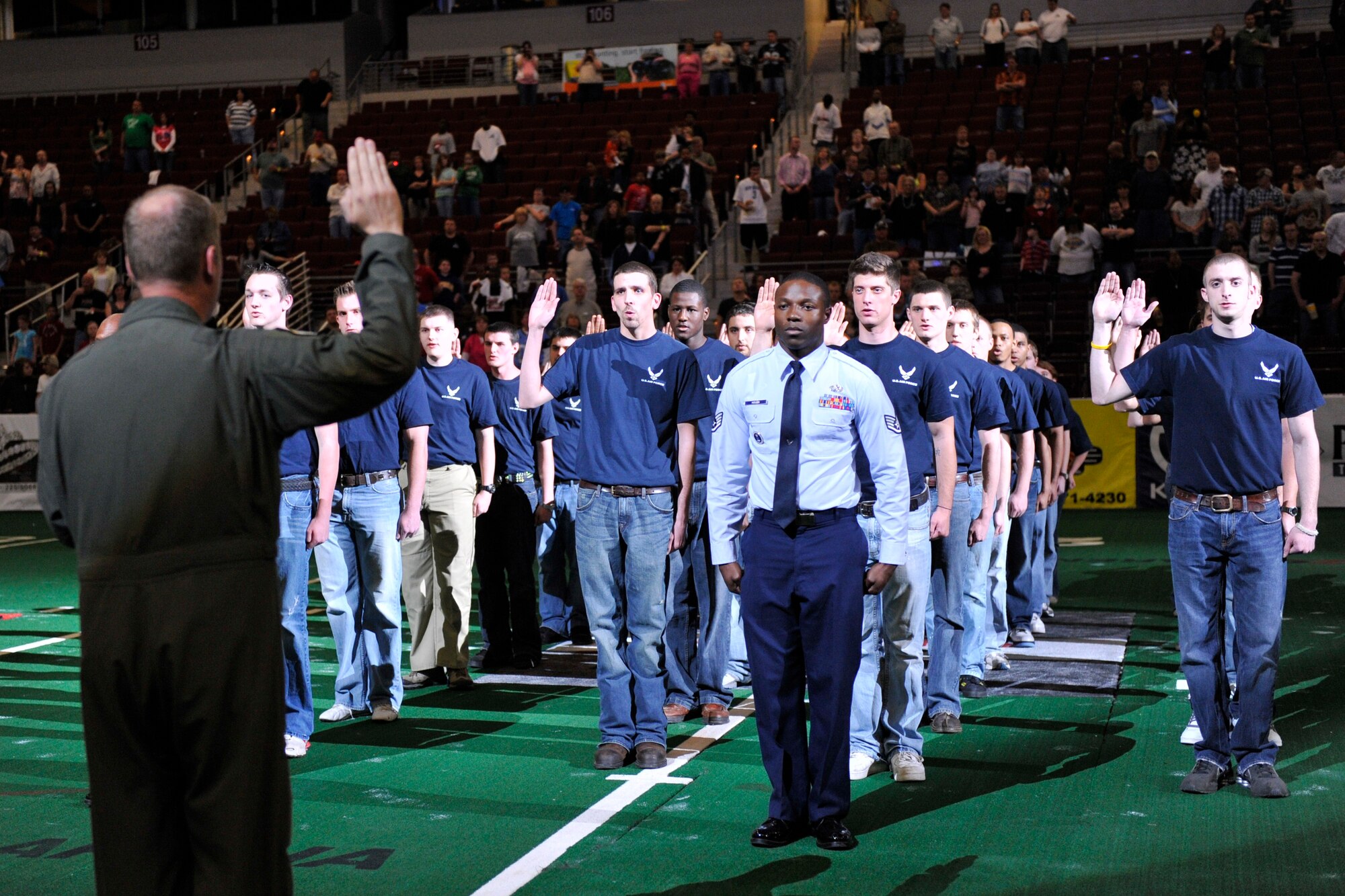 Col. Michael Zick, 19th Airlift Wing vice commander, swears in 32 Air Force recruits March 27 at the Arkansas Diamond’s Military Appreciation Night at Verizon Arena. The recruits committed to joining the delayed entry program before they leave for Air Force basic training. (U.S. Air Force photo by Senior Airman Christine Clark)