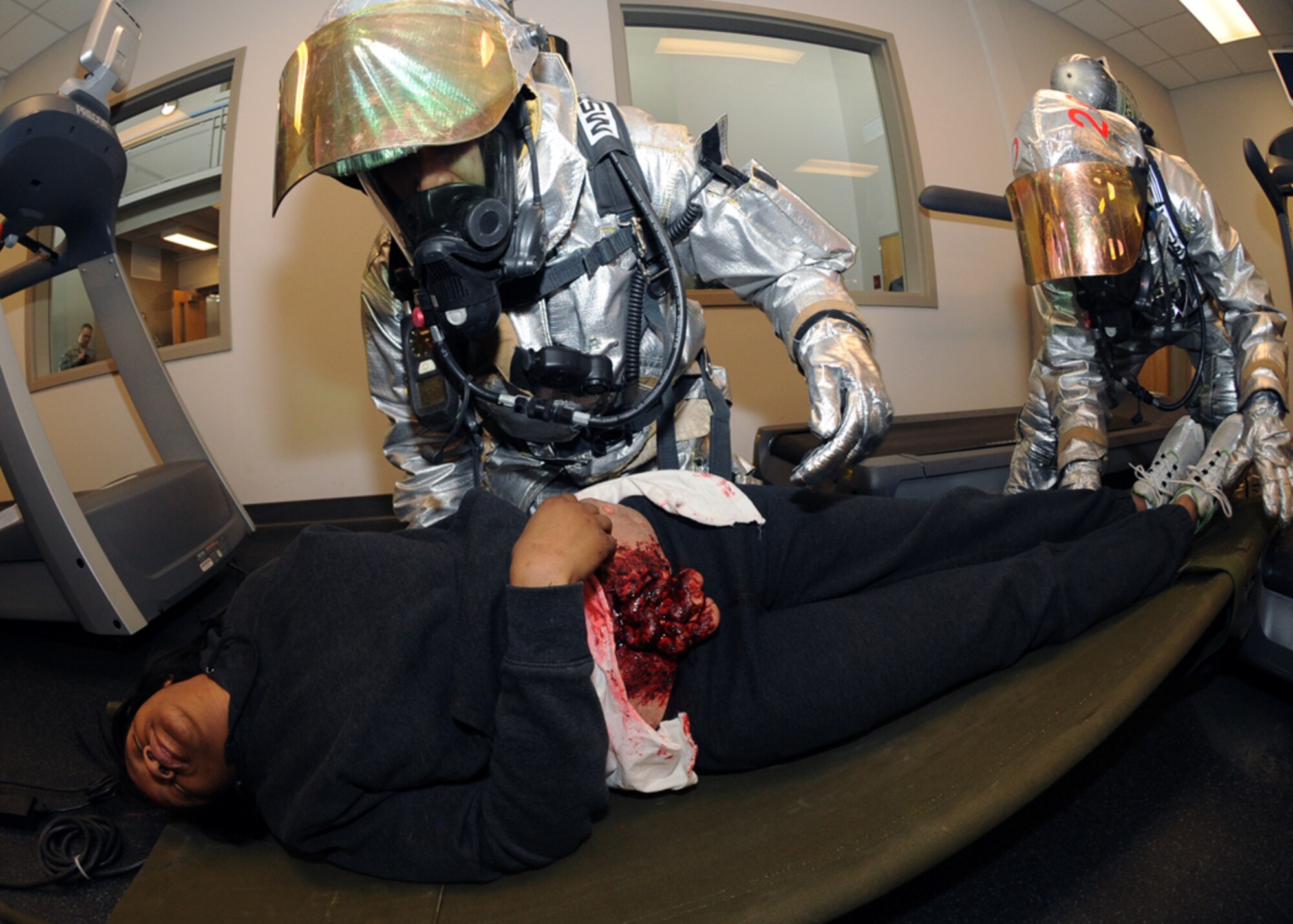 MINOT AIR FORCE BASE, N.D. – Firefighters from the 5th Civil Engineer Squadron place Senior Airman Arbraysha Williams, 5th Force Support Squadron personnelist and simulated victim, on a litter during the major accident response exercise at Minot AFB March 26. Exercises like this provide the installation commander a way to conduct realistic exercises for all installation personnel. (U.S. Air Force photo by Senior Airman Sharida Jackson)