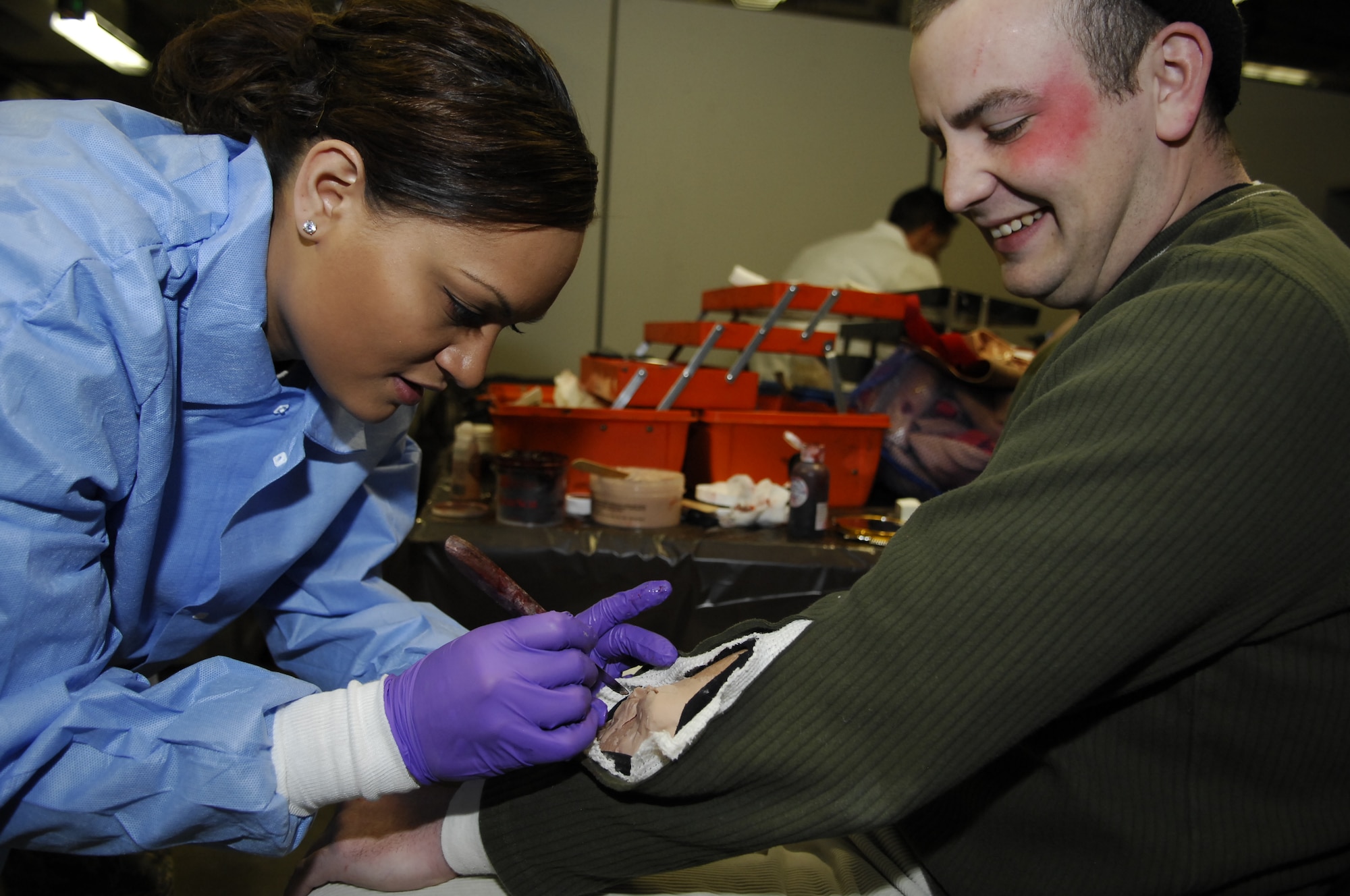 MINOT AIR FORCE BASE, N.D. – Tech. Sgt Jennifer Gaines, 5th Medical Support Squadron resource management flight chief, creates a fake moulage wound on Staff Sgt. Ryan Muha, 5th Munitions Squadron munitions custody account manager, at the Minot AFB medical treatment facility here March 26. More than 50 Airmen volunteered to become “victims” for a base-wide massive accident response exercise held March 26. Exercises like this MARE prepare base personnel for possible real-world situations as well as testing communication and emergency procedures. (U.S. Air Force photo by Tech. Sgt. Thomas Dow)