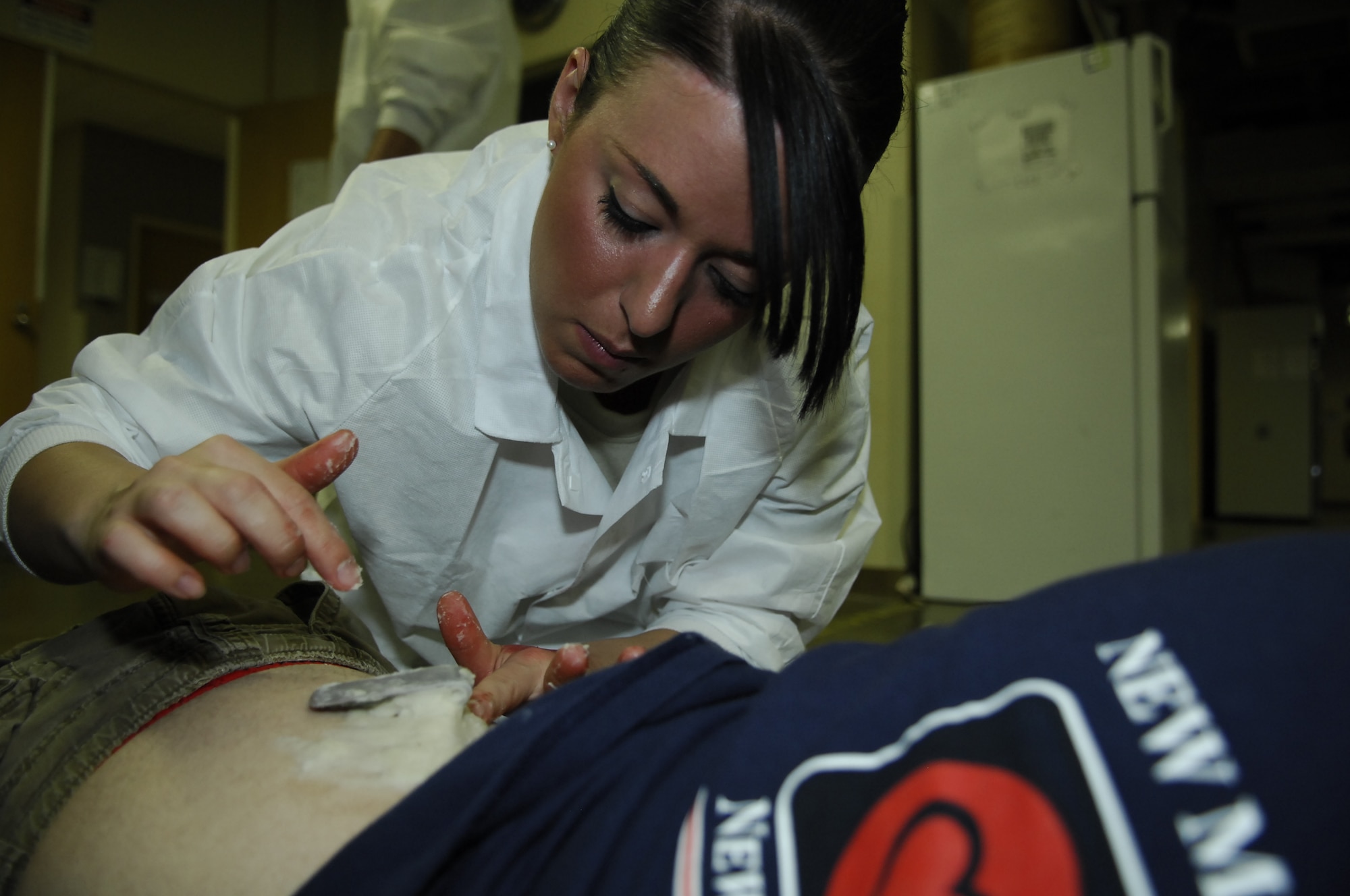 MINOT AIR FORCE BASE, N.D. – Senior Airman Jennifer Cook, 5th Medical Operations Squadron dental technician, creates a fake moulage wound on a volunteer at the Minot AFB medical treatment facility here March 26. More than 50 Airmen volunteered to become “victims” for a base-wide massive accident response exercise held March 26. Exercises like this MARE prepare base personnel for possible real-world situations as well as testing communication and emergency procedures. (U.S. Air Force photo by Tech. Sgt. Thomas Dow)