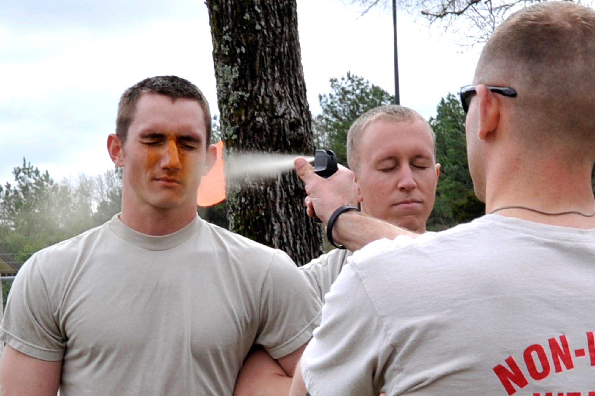 Senior Airman John Wilkerson, a 19th Security Forces Squadron patrolman, gets pepper sprayed while Staff Sgt. Ian Becker, a 19th SFS patrolman, waits his turn March 25 at Camp Warlord. 19th SFS instructors utilized three days to certify about 130 security forces members. (U. S. Air Force photo by Senior Airman Christine Clark)
