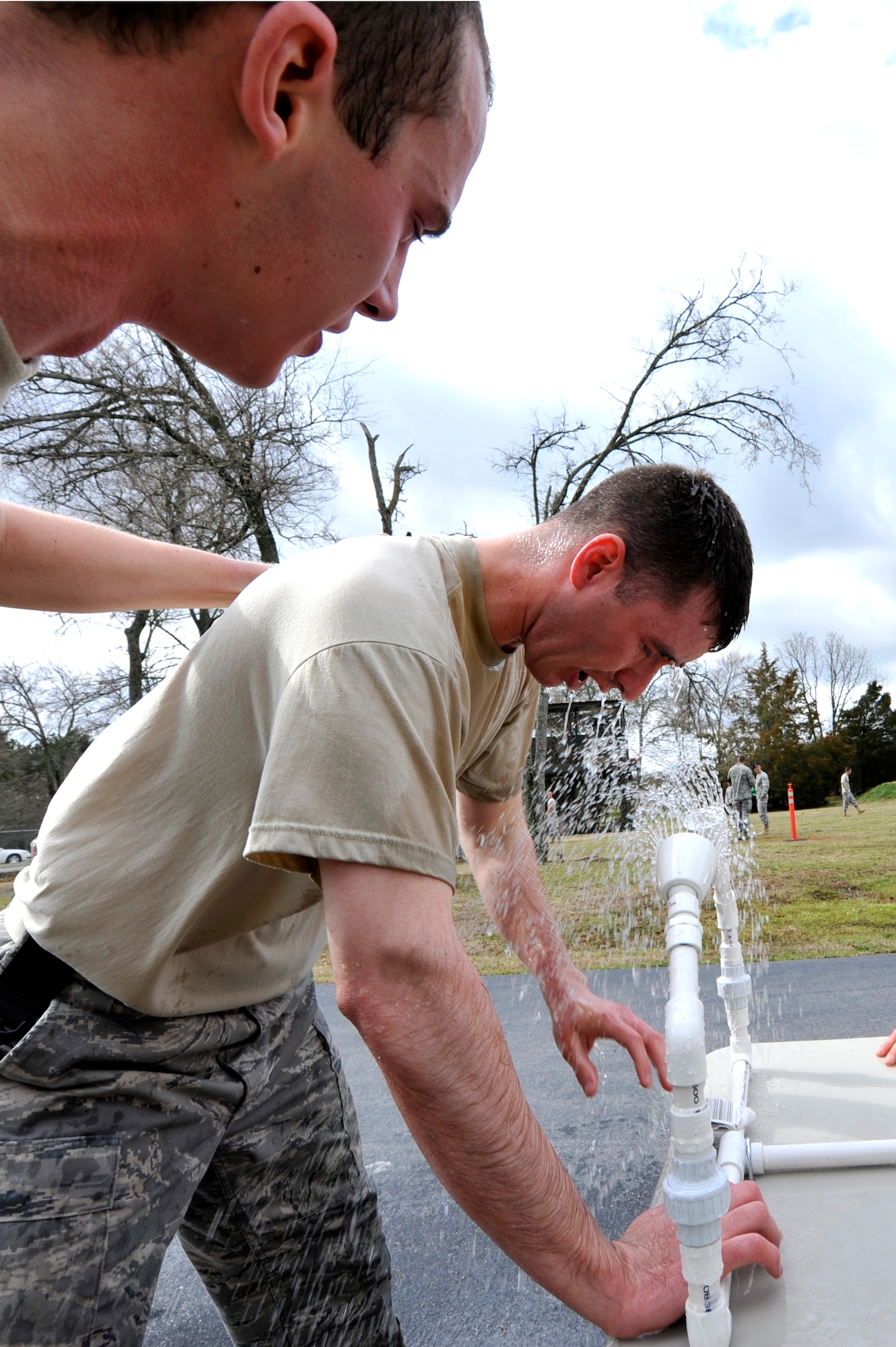 2nd Lt. Andrew York, a 19th Security Forces Squadron flight commander, motivates Staff Sgt. Robert Miller, a 19th SFS patrolman, while he flights though the pain of the pepper spray March 25 at Camp Warlord. The pepper spray also known as Oleoresin Capsicum lasts for an average of 30 to 45 minutes, with diminished effects lasting for hours. (U.S. Air Force photo by Senior Airman Christine Clark)