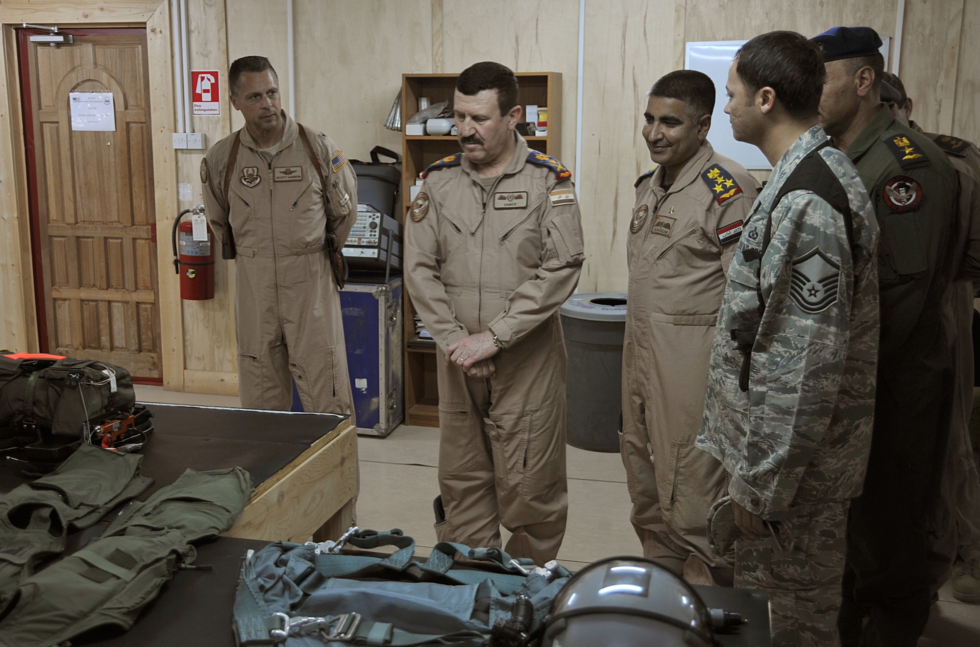 U.S. Air Force Master Sgt. Eliezer Huertas (right) explains the use of  life-support equipment Iraqi Air Force students will use during their training to Brig. Gen. Scott Hanson and Iraqi Air Force Gen. Lt. Gen. Anwar Hamad Amen Ahmed at the 52nd Air Expeditionary Advisor Squadron at Combat Operations Base Speicher, Iraq, March 11, 2010.  General Hanson is the commander of the 321st Air Expeditionary Wing and Iraqi Training and Advisory Mission ? Air Force.  General Anwar is the commander of the Iraqi Air Force.  Sergeant Huertas is assigned to the 412 Operational Support Squadron, Edwards Air Force Base, Calif.  (U.S. Air Force photo/Staff Sgt. Quinton Russ/Released)	