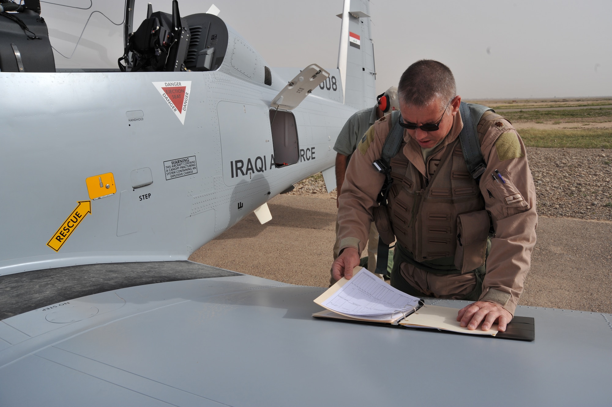 U.S. Air Force pilot Maj. Rick Kelley looks over paper work before he conducts pre-flight inspections on an Iraqi Air Force T-6 trianer before flying a combat training sortie at Combat Operations Base Speicher, Iraq, March 15, 2010.  Maj. Kelley is an instructor pilot training the Iraqi Air Force and deployed from the 559th Flying Training Squadron, Randolph AFB, TX.  This inaugural class will generate the initial cadre of Iraqi Air Force T-6 instructor pilots.
(U.S. Air Force photo by/Staff Sgt Quinton Russ/released)