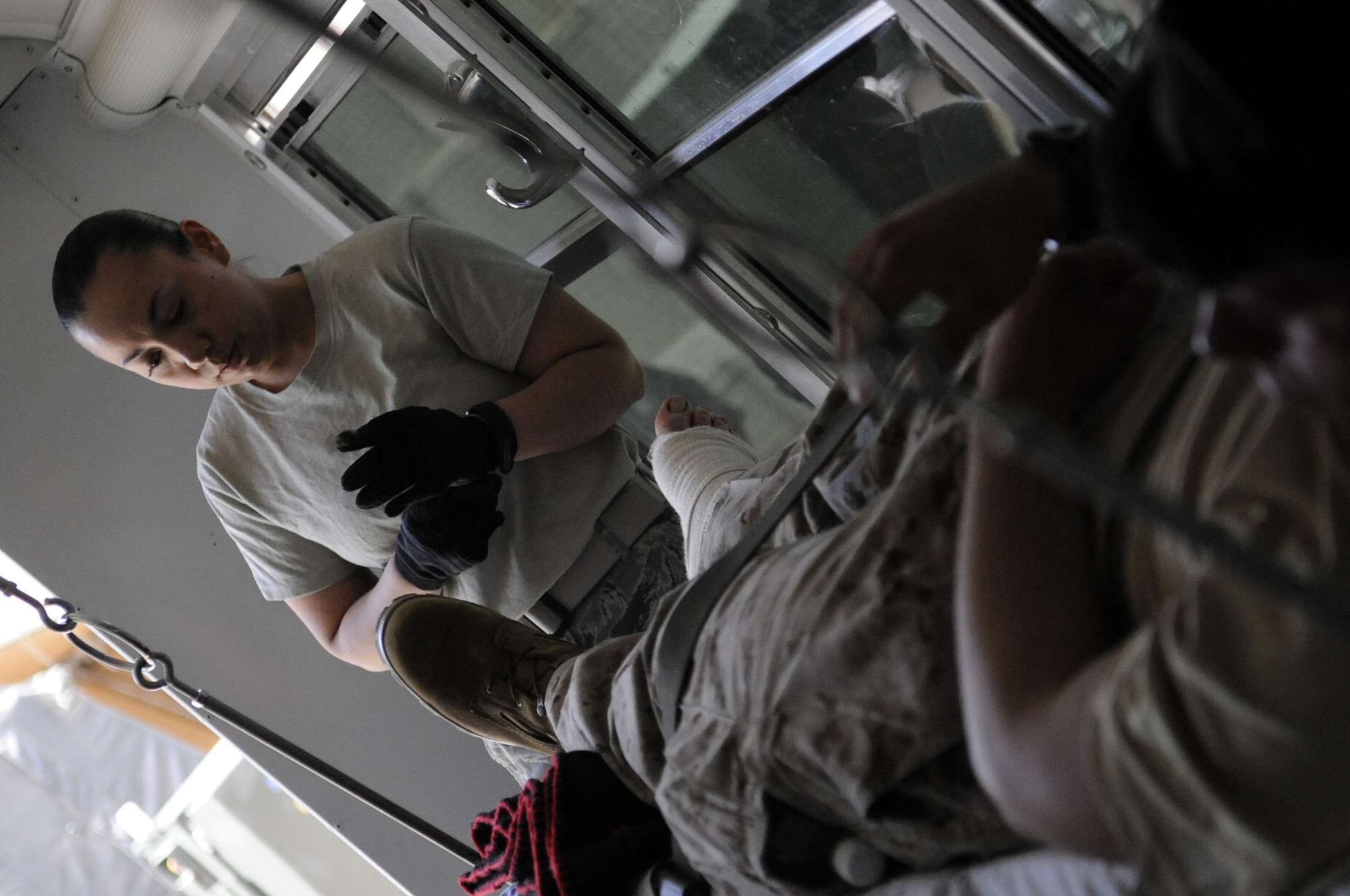 Staff Sgt. Cecilia Gomez-Ramos secures her gloves for the transport of patients onto a bus March 25 at Camp Bastion, Afghanistan. Sergeant Gomez-Ramos is from Travis AFB, California. (U.S. Air Force photo/Senior Airman Nancy Hooks/Released)
