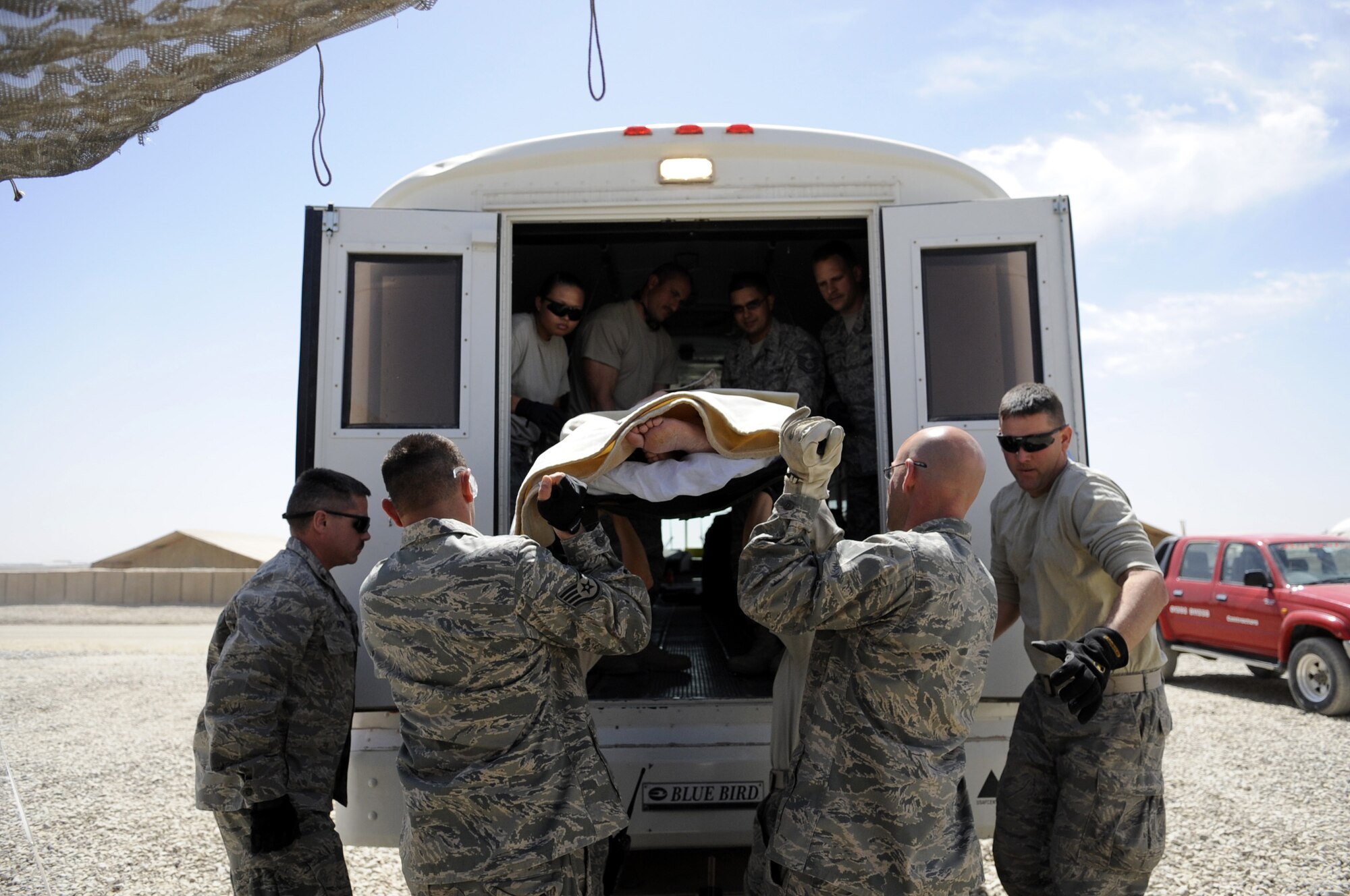 Members from the 451st Expeditionary Aeromedical Evacuation Squadron transport a patient from the Contingency Aeromedical Staging Facility to a bus in Camp Bastion, Afghanistan March 25. The AE team  took the patient to a C130J and flew to Kandahar Airfield for further treatment. For more information about the AE/CASF mission, see page 6. (U.S. Air Force photo by Senior Airman Nancy Hooks/Released)
