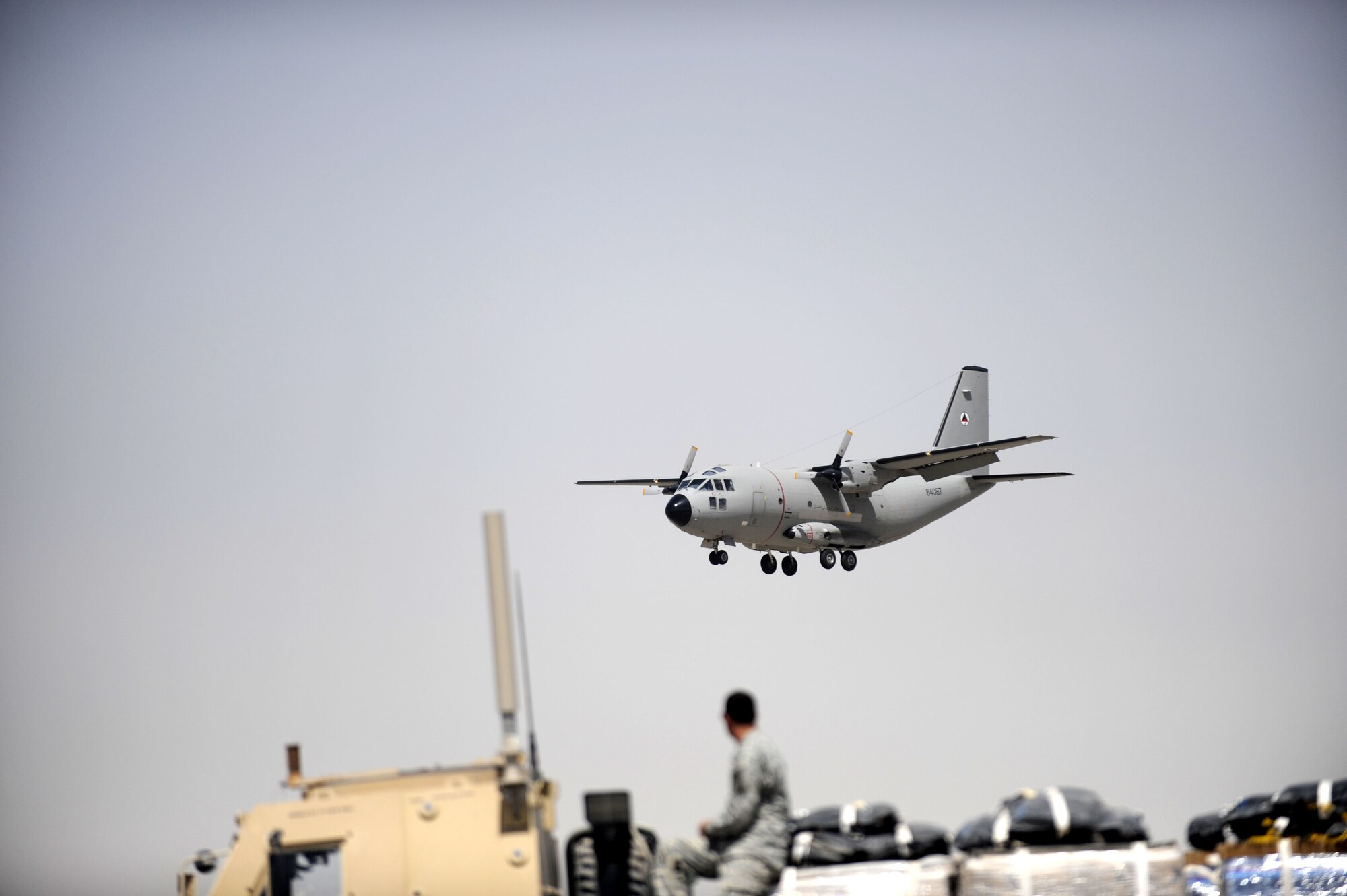 Lt. Col. James Piel,left, 538th Air Expeditionary Advisory Squadron commander and C-27 Spartan pilot-mentor and First Lieutenant Faiz M. Ramaki, an Afghanistan National Army Air Corps (ANAAC) C-27 pilot fly their first operational mission March 24 at Kandahar Airfield, Afghanistan.  Lieutenant Ramaki is the first Afghan pilot to mark in history.  (U.S. Air Force photo by Senior Airman Nancy Hooks/Released)