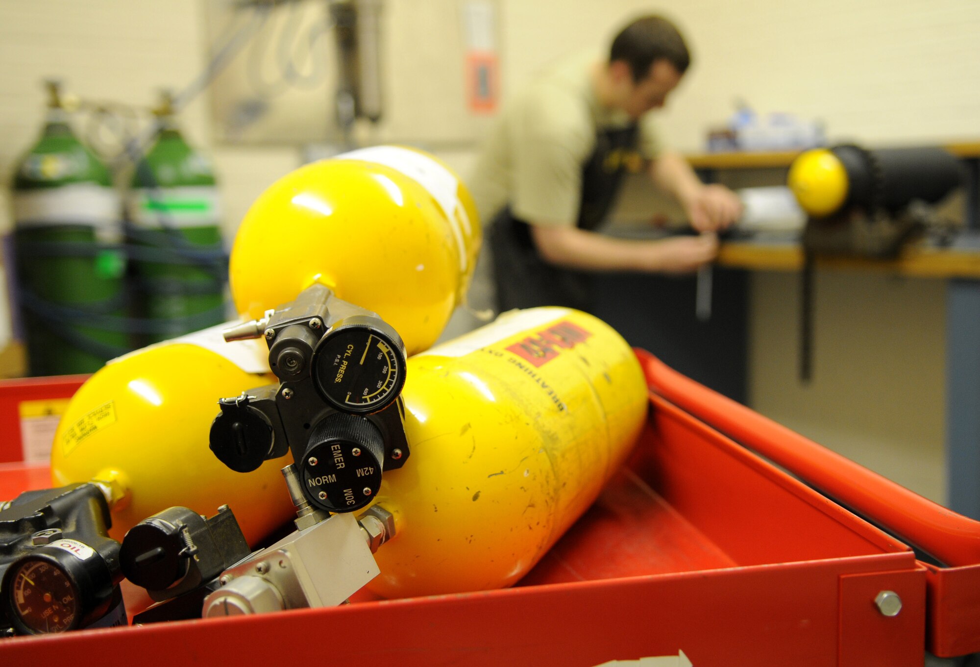 RAF MILDENHALL, England – Unserviceable portable oxygen cylinders wait for repairs while Airman 1st Class Andrew Mills, 100th Maintenance Squadron electrical and environmental journeyman, replaces a regulator on an oxygen cylinder during servicing at the E&E backshop March 30. Airman Mills ensures the serviceability and integrity of each oxygen cylinder to provide aircrew a reliable source of oxygen in case of emergency. (U.S. Air Force photo/ Staff Sgt. Jerry Fleshman)  