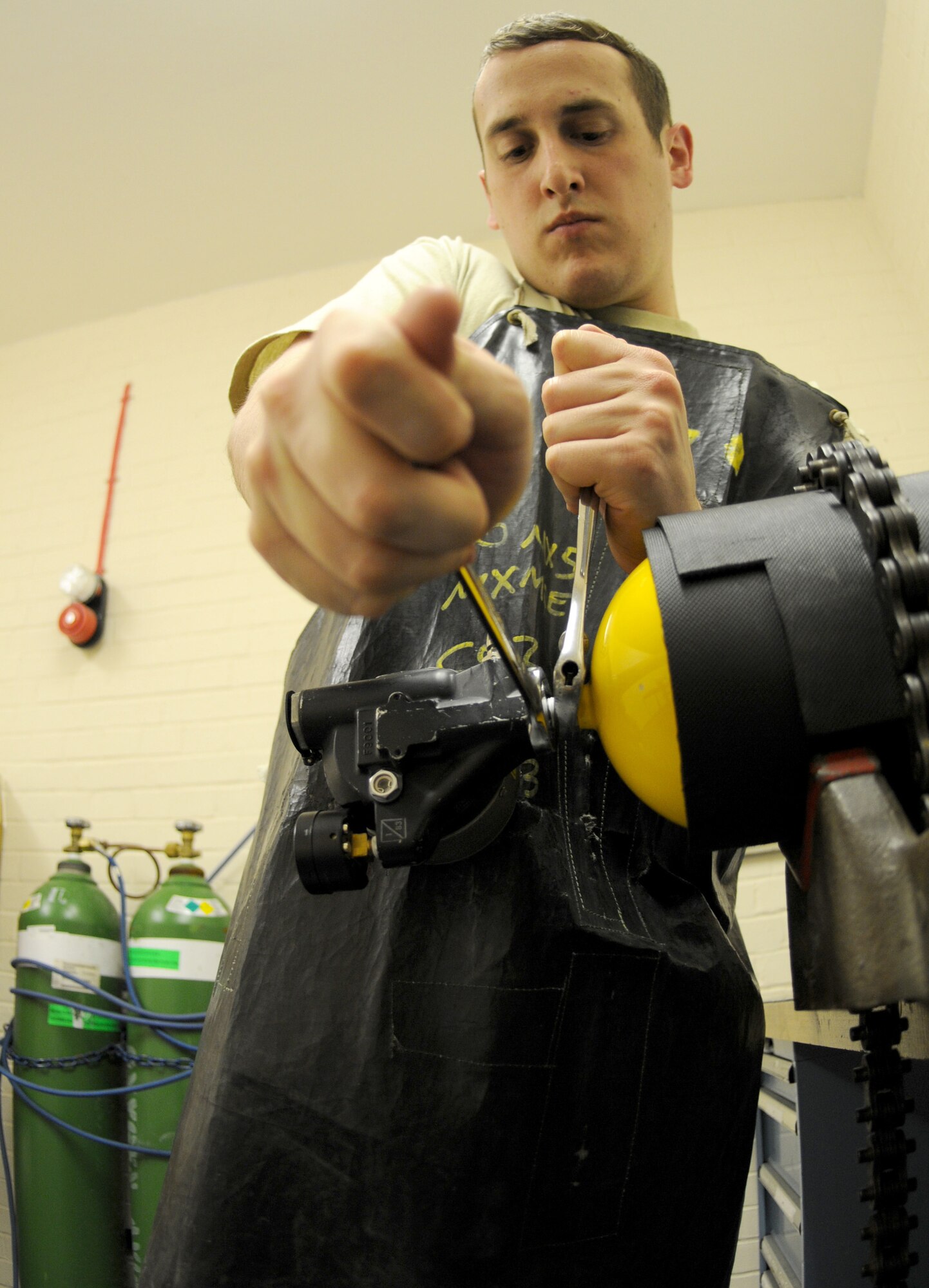 RAF MILDENHALL, England – Airman 1st Class Andrew Mills, 100th Maintenance Squadron electrical and environmental journeyman, tightens down a regulator to a portable oxygen cylinder during routine maintenance at the E&E back shop March 30. The regulator restricts high pressure oxygen to a breathable level. (U.S. Air Force photo/ Staff Sgt. Jerry Fleshman)