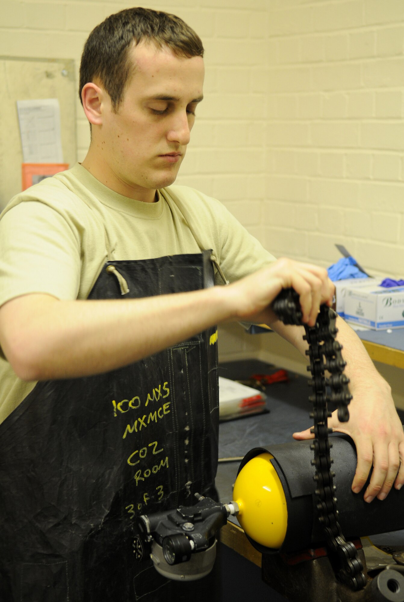RAF MILDENHALL, England – Airman 1st Class Andrew Mills, 100th Maintenance Squadron electrical and environmental journeyman, uses a chain vise to hold a portable oxygen cylinder during servicing at the E&E back shop March 30. Airman Mills ensures the serviceability and integrity of each oxygen cylinder to provide aircrew a reliable source of oxygen in case of emergency. (U.S. Air Force photo/ Staff Sgt. Jerry Fleshman)  