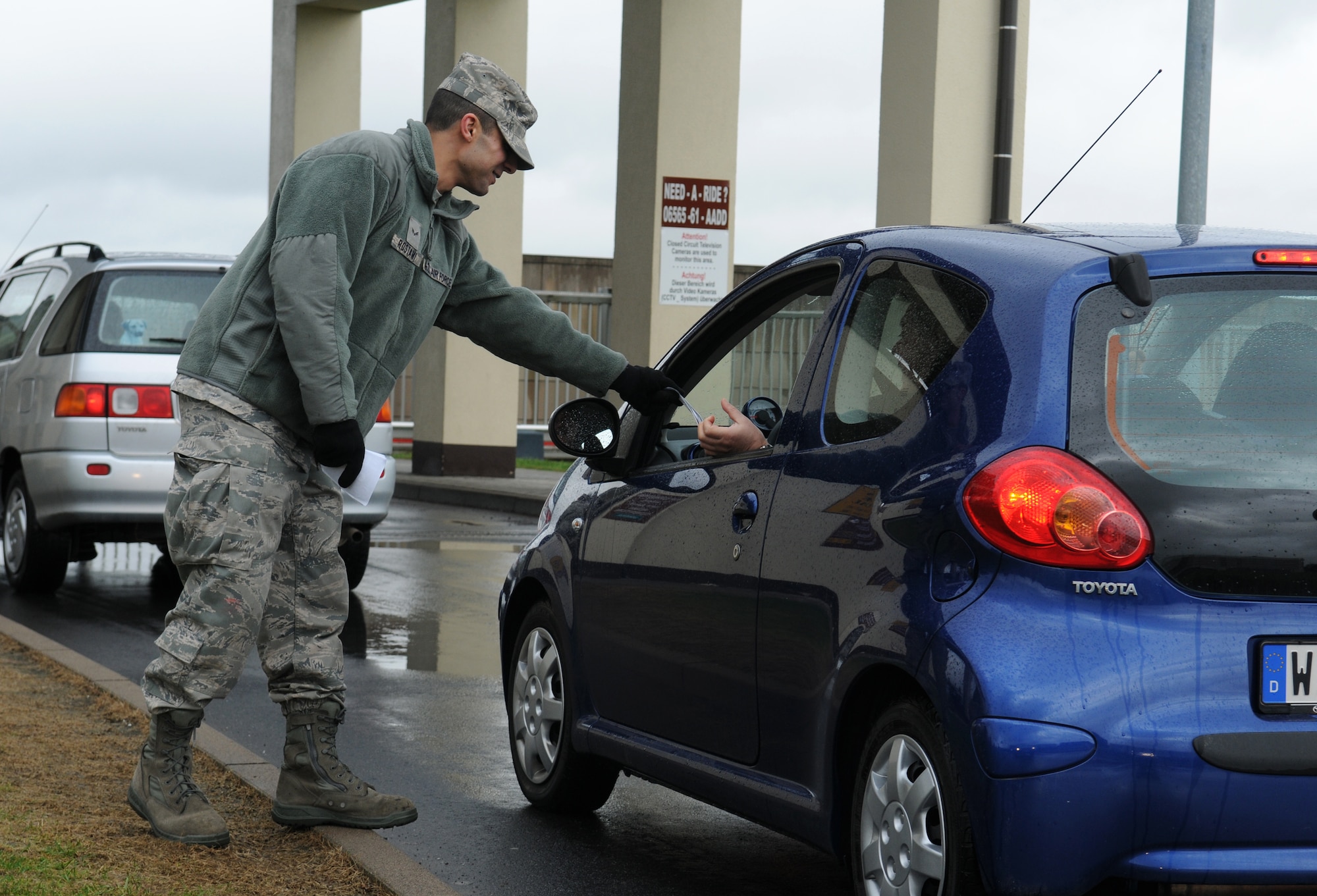 SPANGDAHLEM AIR BASE, Germany – Airman 1st Class Mahyar Rostami, 52nd Civil Engineer Squadron heating, ventilation and air-conditioning journeyman, passes out fliers supporting the Air Force Assistance Fund to people leaving the base March 29. The 2010 AFAF campaign began March 29 and runs until May 7. (U.S. Air Force photo/Senior Airman Nathanael Callon)