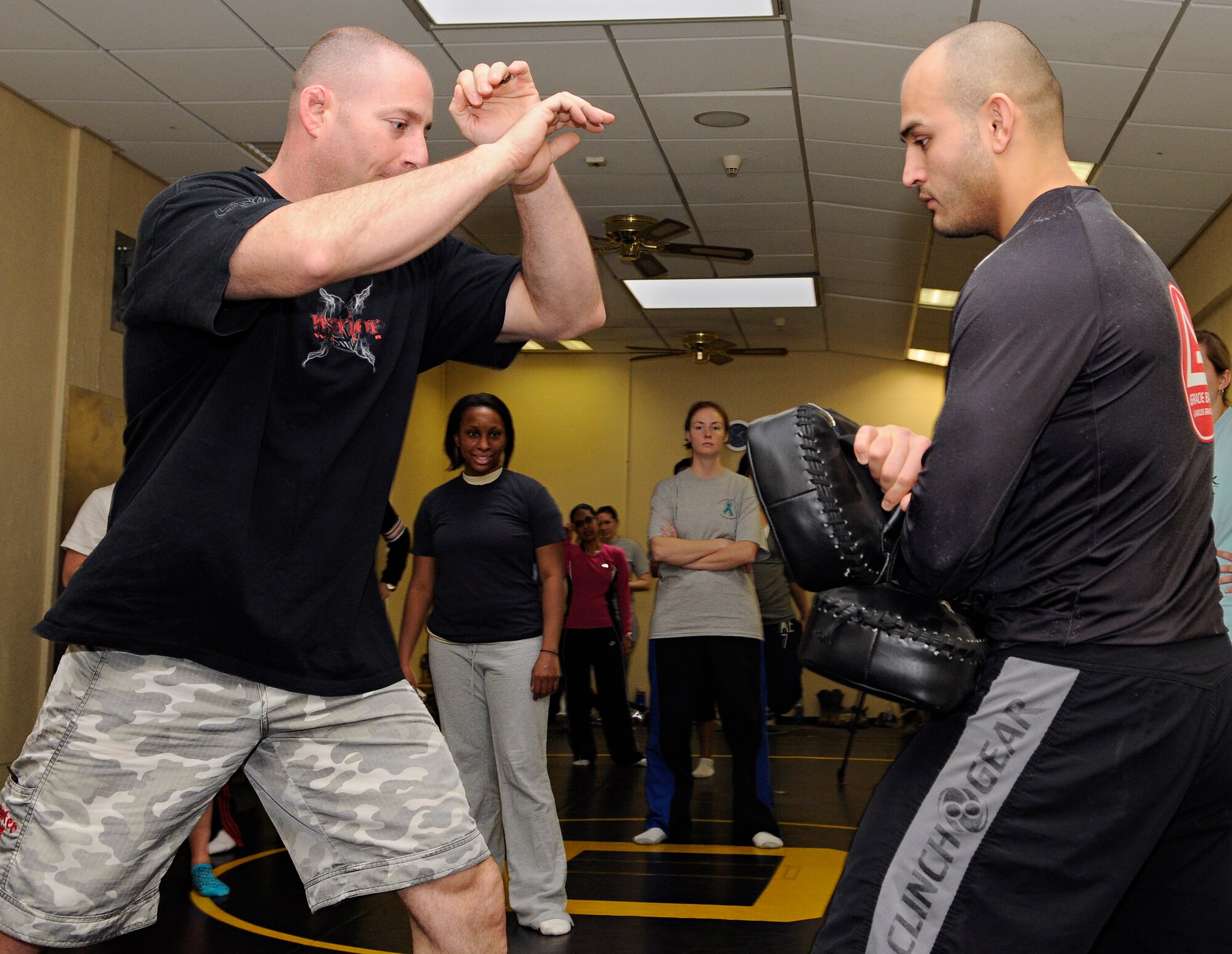 SPANGDAHLEM AIR BASE, Germany – Master Sgt. John Cammarata, left, 52nd Civil Engineer Squadron member and mixed martial arts coach, and Jesus Carlos, husband of Staff Sgt. Leonor Carlos, 52nd Medical Operations Squadron, demonstrate how to strike a person’s abdomen using knees during a self-defense class at Skelton Memorial Fitness Center March 26. This class was among many events focused on preventing sexual assault during Sexual Assault Awareness Month. (U.S. Air Force photo/Senior Airman Benjamin Wilson)
