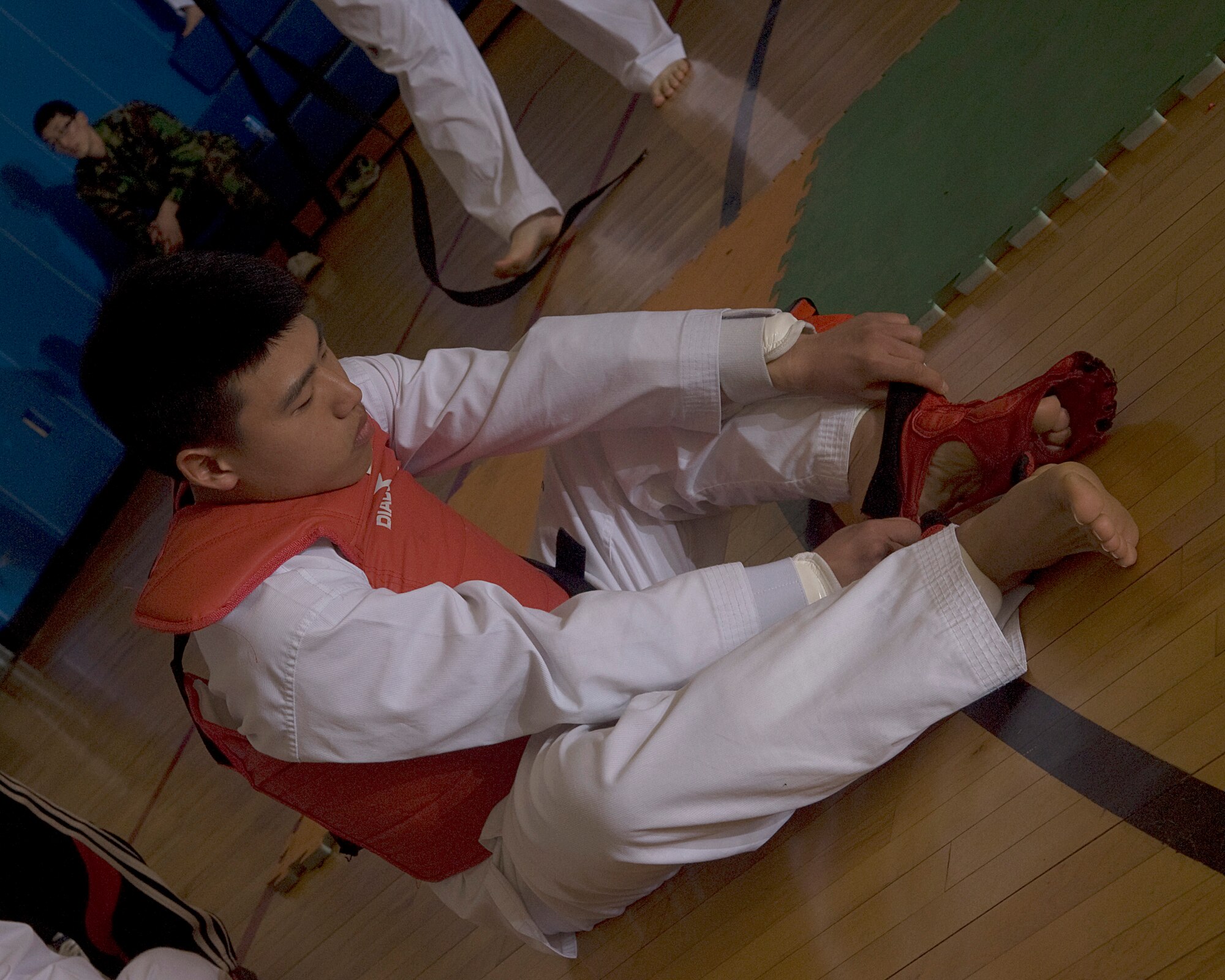 KUNSAN AIR BASE, Republic of Korea -- Airman Ji Seung Kang, 38th Fighter Group, puts a foot guard on during the 7th Republic of Korea Air Force and U.S. Air Force Taekwondo Tournament March 23. Taekwondo is a martial art made up of high standing and jump kicks, with some punches thrown in the mix. (U.S. Air Force photo/Senior Airman Roy Lynch)