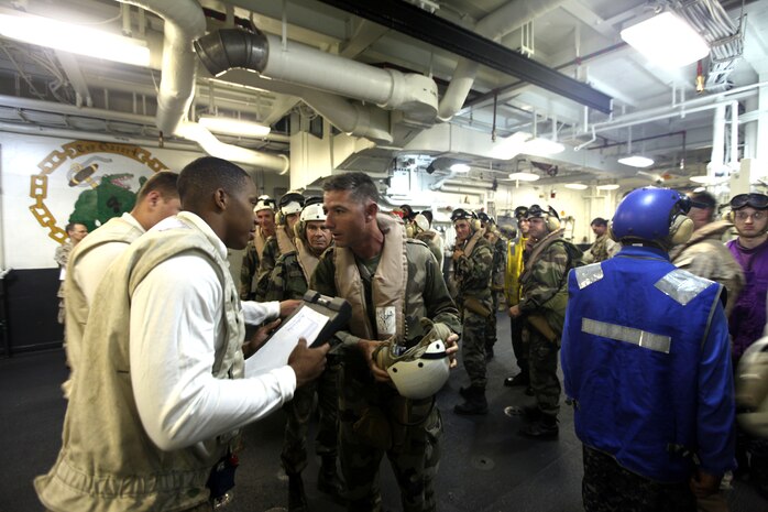 Marine LCpl. Antoine Sanders verifies a roster with LtCol. Valery Putz of the French Foreign Legion as a team from the French Foreign Legion's 13th Demi-Brigade arrive on USS Nassau, March 31, 2010.  The team of French soldiers traveled from the east-African country of Djibouti to meet with commanding officers of the 24th Marine Expeditionary Unit, Amphibious Squadron 8, and USS Nassau as part of a key leader engagement between the two countrie's services in an effort to reinforce military ties and familiarize the French troops with the unique relationship of the Marine-Navy team.