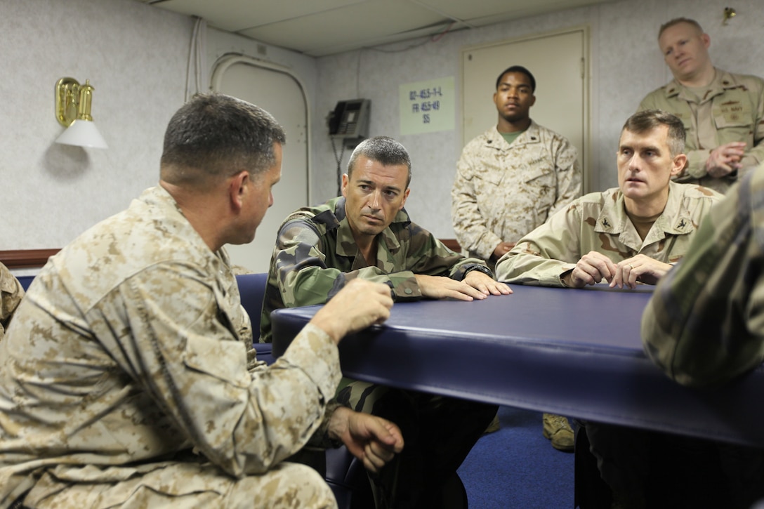Col. Thierry Burkhard (center), commanding officer of the French Foreign Legion's 13th Demi-Brigade, is given a presentation on the capabilities of the 24th Marine Expeditionary Unit by the unit's commanding officer, Col. Pete Petronzio (left) during a key leader engagement visit between the U.S. Marines, Navy and French Foreign Legion aboard USS Nassau, March 31, 2010.  (Official U.S. Marine Corps photo by Capt. Robert Shuford)