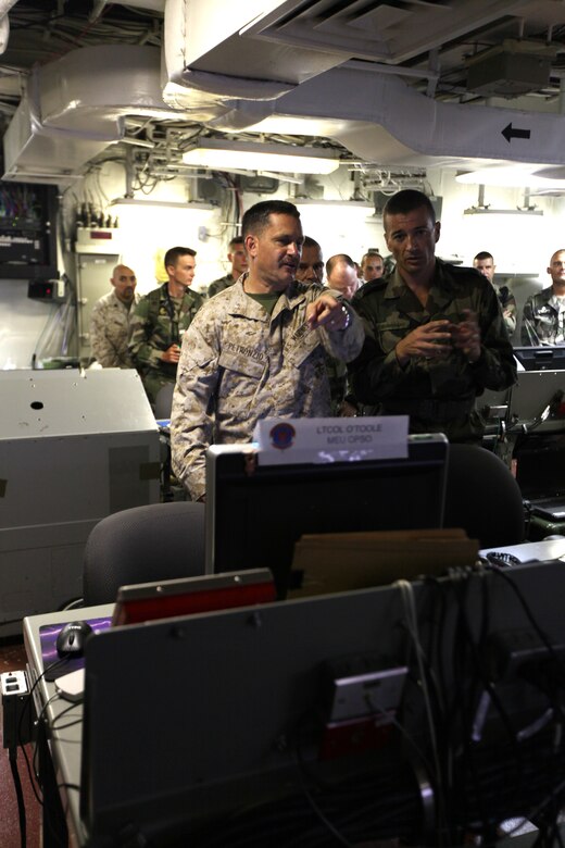 Col. Pete Petronzio, commanding officer, 24th Marine Expeditionary Unit, explains the functions of the Marine operations center aboard USS Nassau to Col. Thierry Burkard, commanding officer of the French Foreign Legion's 13th Demi-Brigade March, 31, 2010.  The 24th MEU hosted a visit with a team of French soldiers from the 13th Demi-Brigade as a key leader engagement between the U.S. and French units in an effort to reinforce military ties and familiarize the French with the unique, Marine-Navy team that comprises a Marine Expeditionary Unit.