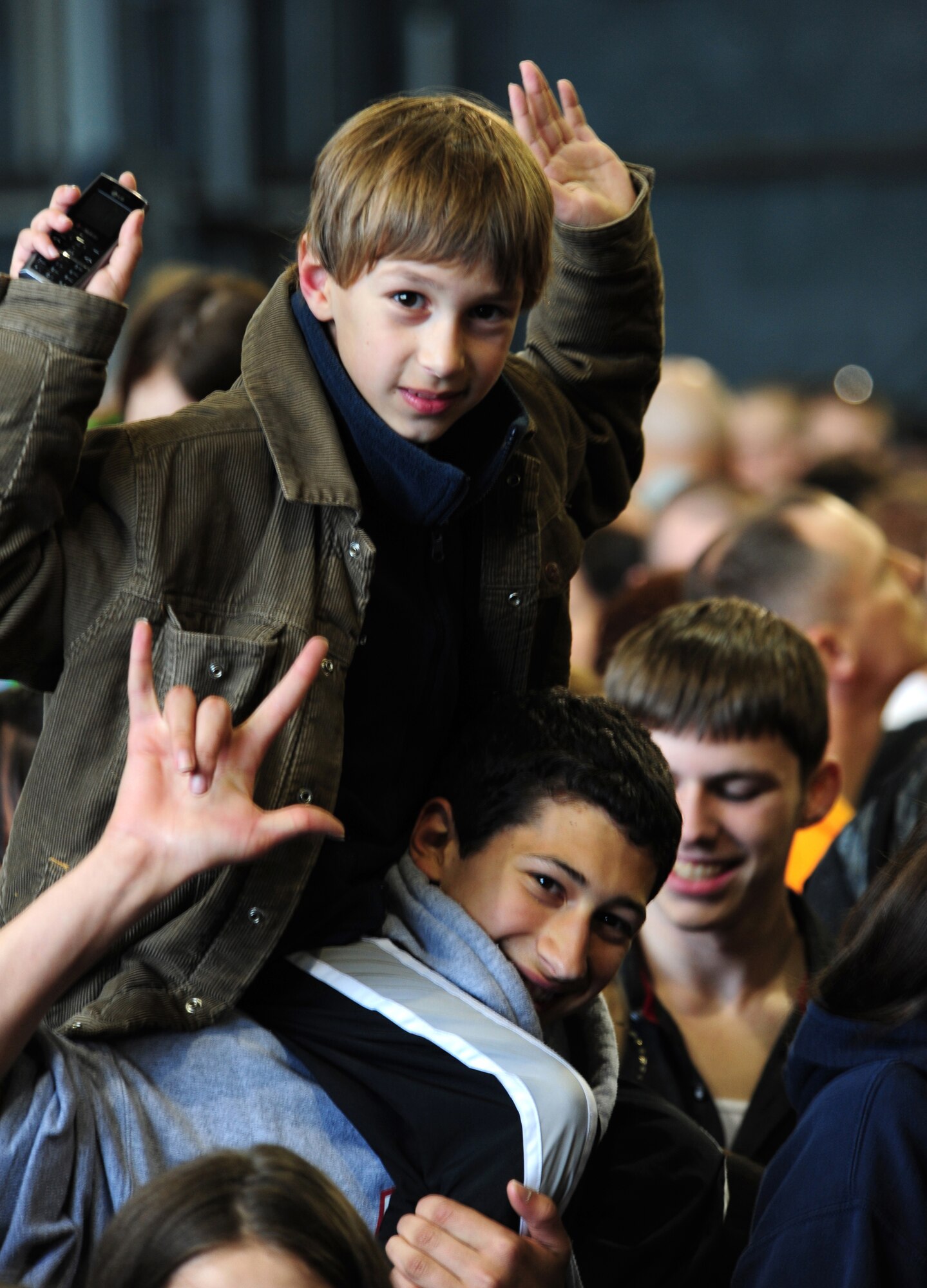 William Tremaglio, 10, son of U.S. Army Colonel Ralph Trmaglio, sits on his brother, Patrick's, 16, shoulders while waiting for Toby Keith to take the stage at a free concert on Ramstein Air Base Germany, May 1, 2010.  The Toby Keith concert, sponsored by the United Services Organization and Armed Forces Entertainment, was designed to entertain and help boost the morale of troops and their families.  Toby Keith will be making stops throughout Germany, Korea and the Persian Gulf during his 14-day country tour.  (U.S. Air Force photo by Staff Sgt. Jocelyn Rich)
