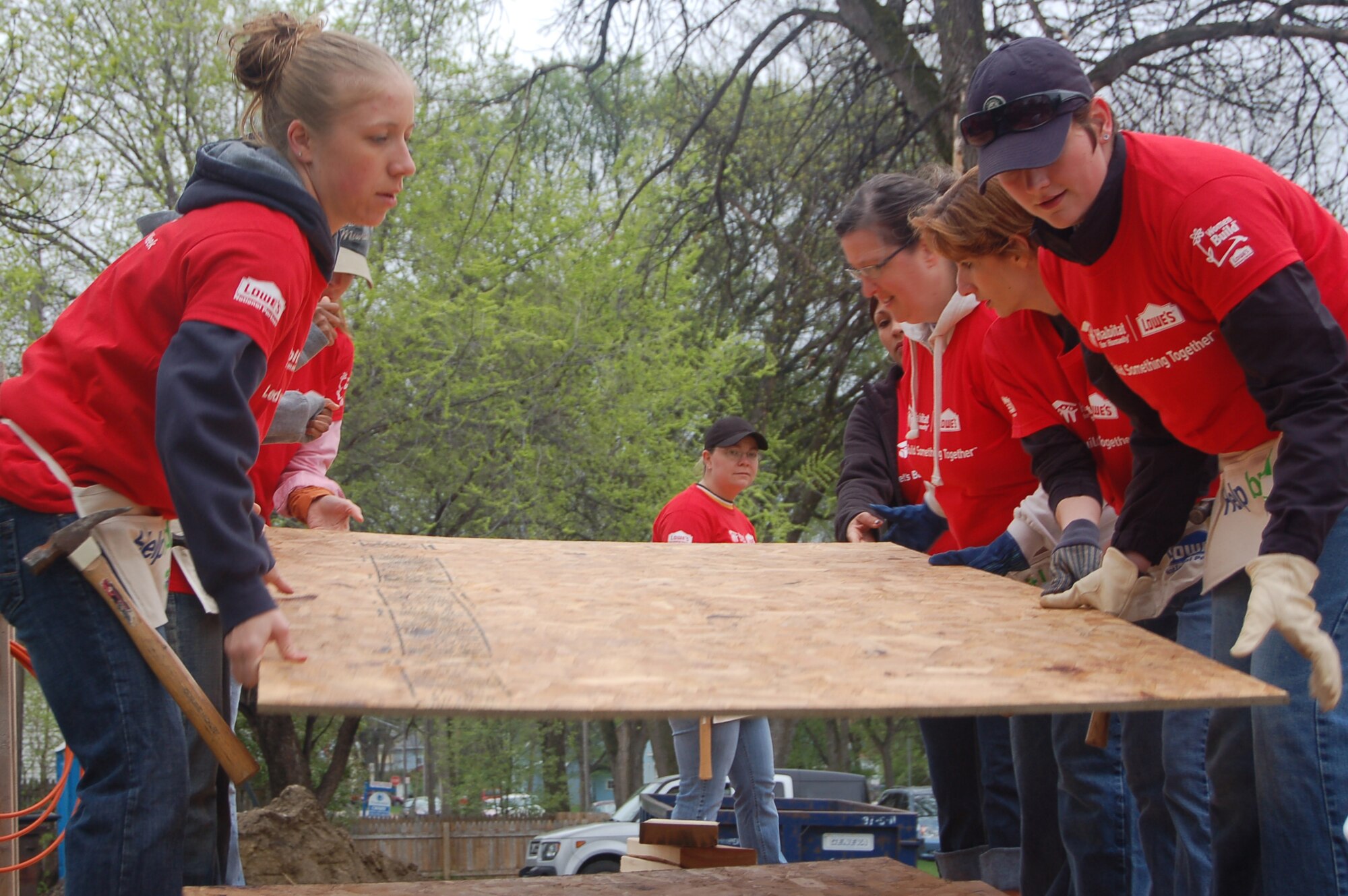 Airmen from the 319th Air Refueling Wing, work together to organize pieces of plywood into a pile at the new Red River Valley Habitat for Humanity build, May 1. These Airmen are volunteering their time to help build a home in Grand Forks, N.D. for single mother Anna Sepeda and her three children. (U.S. Air Force photo by 2nd Lt. Anastasia Wasem)