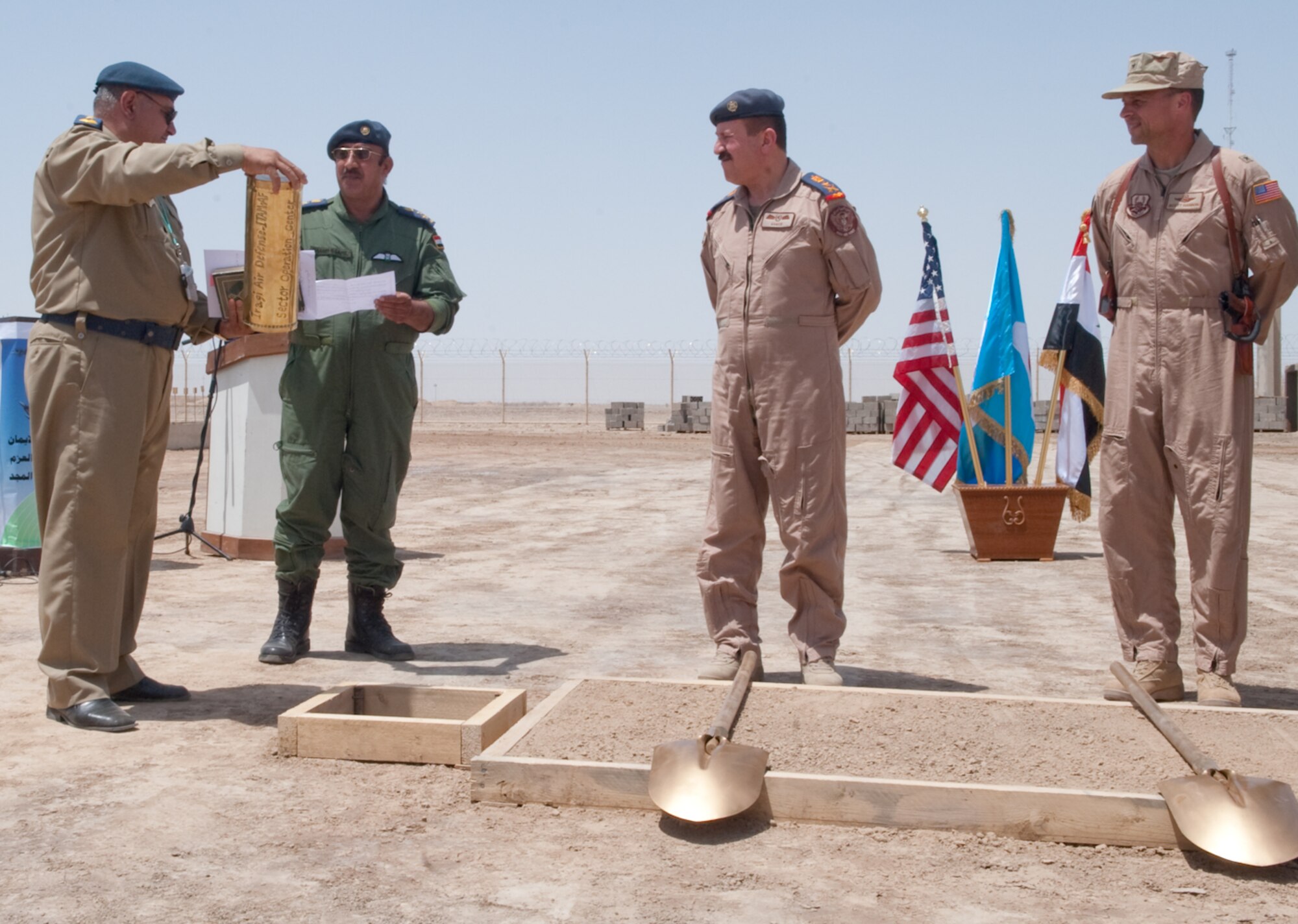 Iraq Air Force Commander Staff Lt. Gen. Anwar (center) and Air Force Brig. Gen. Scott Hanson (right), commander, 321st Air Expeditionary Wing, stand by ceremonial shovels while preparing to bury an Iraqi time capsule during a dedication ceremony at Ali Base, Iraq, April 27, 2010.  (U.S. Air Force photo by Senior Master Sgt. Elizabeth Gilbert/released)