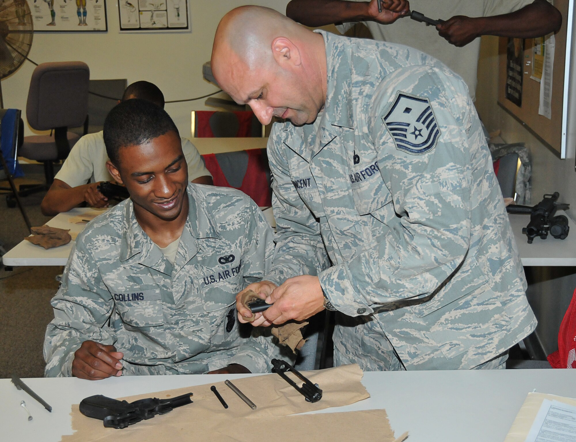 Master Sgt. Bryan Vincent, 403rd SFS first sergeant, shows Senior Airman Hampshire Collins proper disassembly and cleaning of his M-9 after completing proficiency training on May 1. Sergeant Vincent has been a Reservist with the 403rd SFS since 1997.