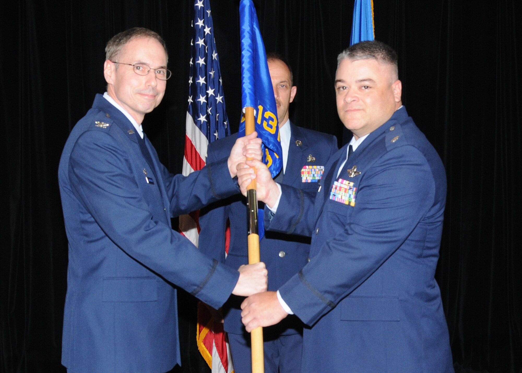 Lt. Col. Ken Eaves receives the guidon and assumes the role of the Operations Group commander from Col. Gregory Champagne, 131st Bomb Wing commander, during a change of command ceremony at Whiteman Air Force Base, May 2. (Photo by Master Sgt. Mary-Dale Amison)