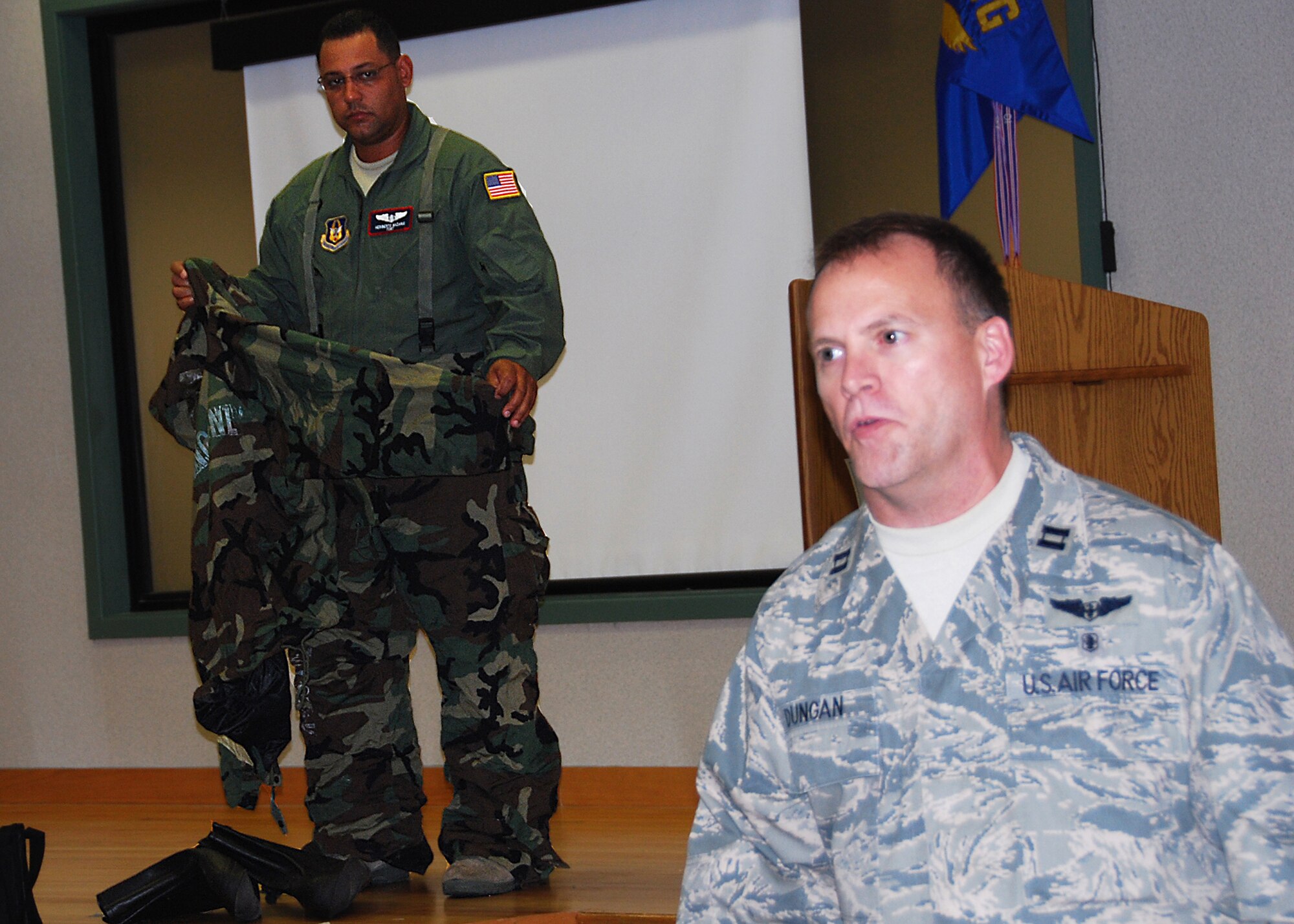 JOINT BASE MCGUIRE-DIX-LAKEHURST, N.J. ? Captain Brad Dungan (front) explains how to properly don a chemical-protective over-garment during a training session here May 2, 2010, as Staff Sgt. Heriberto Nazario demonstrates. Both Airmen are members of the 514th Aeromedical Evacuation Squadron. (U.S. Air Force photo/Staff Sgt. Shawn J. Jones)