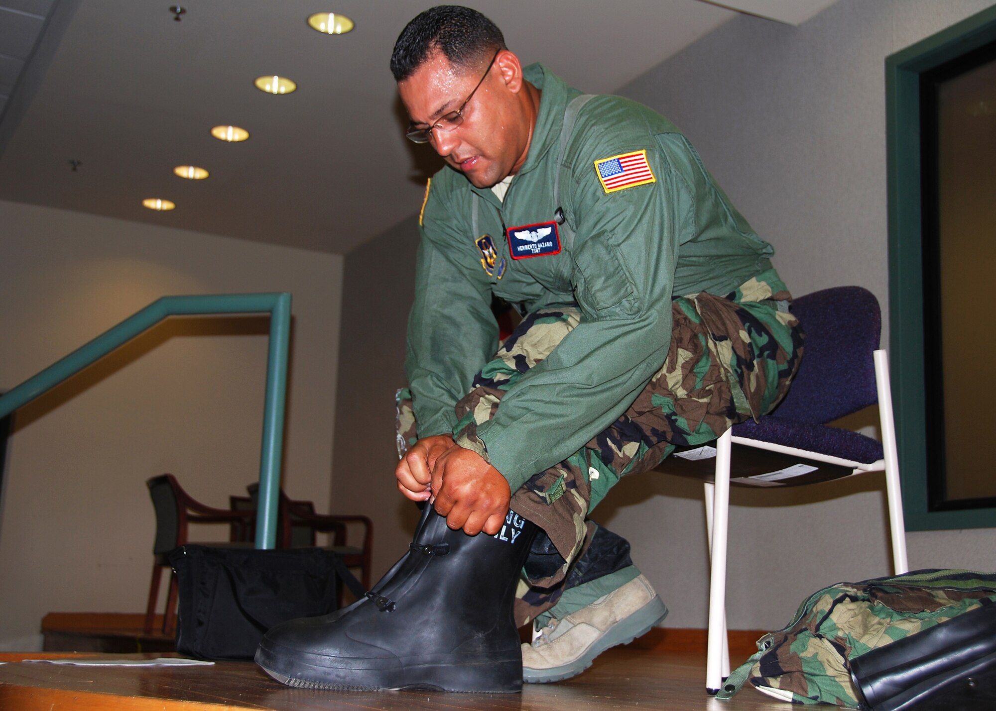JOINT BASE MCGUIRE-DIX-LAKEHURST, N.J. ? Staff Sgt. Heriberto Nazario, a medical readiness specialist with the 514th Aeromedical Evacuation Squadron, demonstrates the proper donning of chemical-protective boots as part of a training session here May 2, 2010. The objective of the training was to familiarize the squadron?s Airmen with the Joint Service Lightweight Integrated Suit Technology, commonly referred to as the JLIST suit. (U.S. Air Force photo/Staff Sgt. Shawn J. Jones)