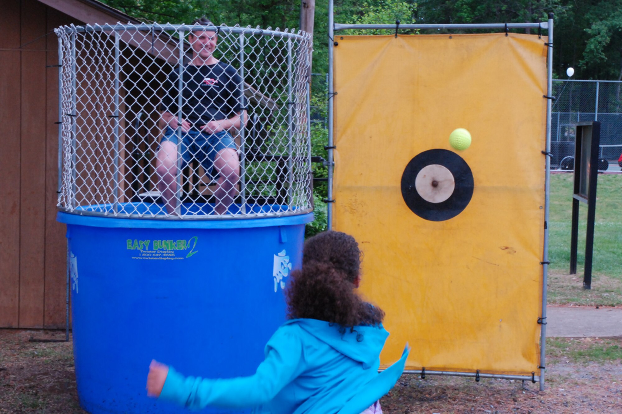 Col. Heath J. Nuckolls, commander, 94th Airlift Wing, prepares to dive in as a young participant aims for the dunking booth at the annual family day event here May 1. Family Day is an opportunity for families to show their thanks and support to reserve members. (US Air Force photo/Capt. Patrick H. Simmons)