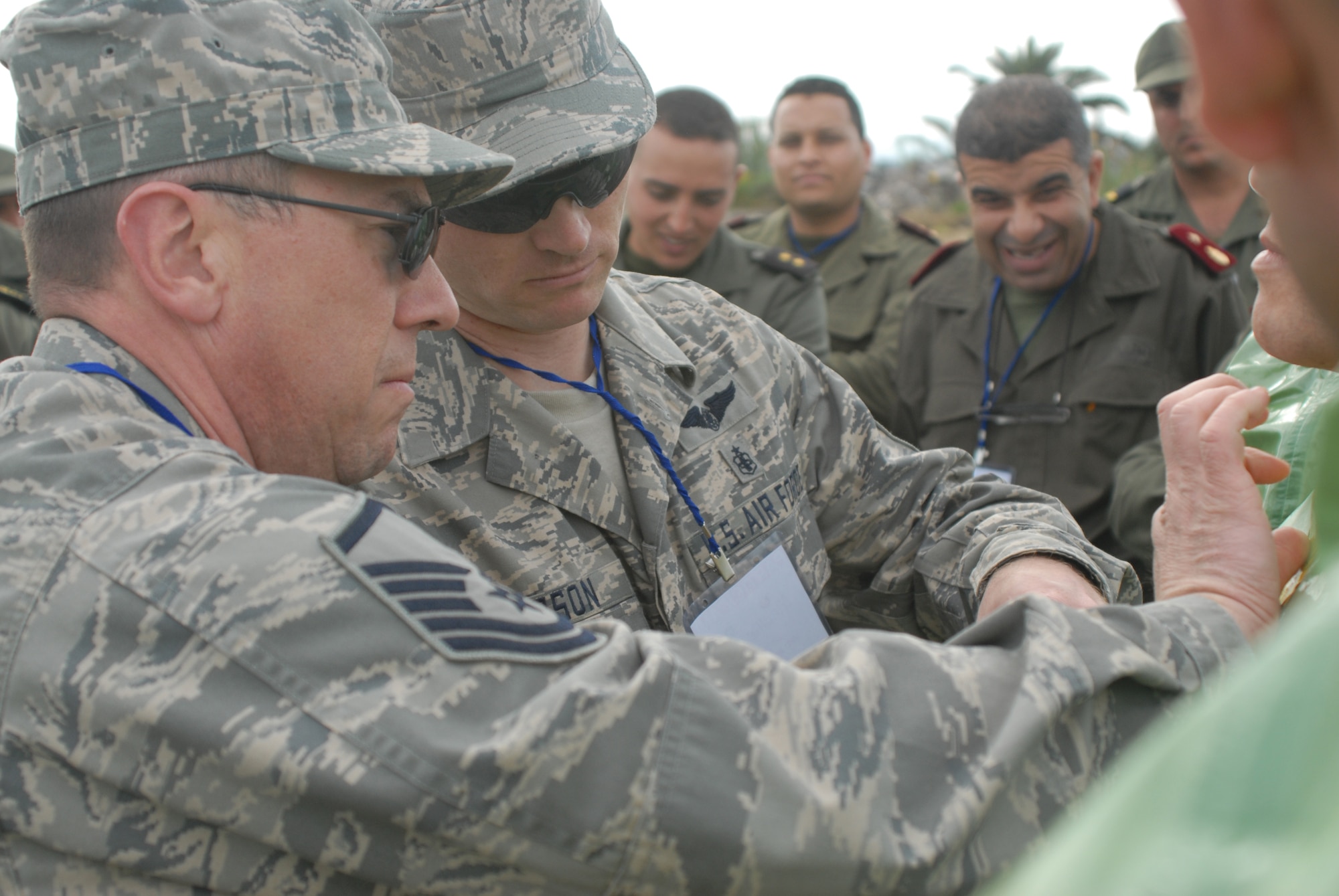 Air Force Master Sgt. Brian Rachocki, an operations NCO assigned to the 84th Civil Support Team, Wyoming National Guard and Master Sgt. Shane Larson a medical technician with the 153rd Medical Group, 153rd Airlift Wing, Wyoming Air National Guard help their Tunisian Army counterparts don chemical protective gear during the MEDLITE-10 exercise at Kharrouba Air Base, Bizerte, Tunisia. United States service members from Wyoming, Arizona, Nevada, and Illinois are in Tunisia as part of the U.S. partnership program with the North African nation exchanging medical treatment practices and programs. (USAF Photo by Master Sgt. Paul Mann/Released)
  