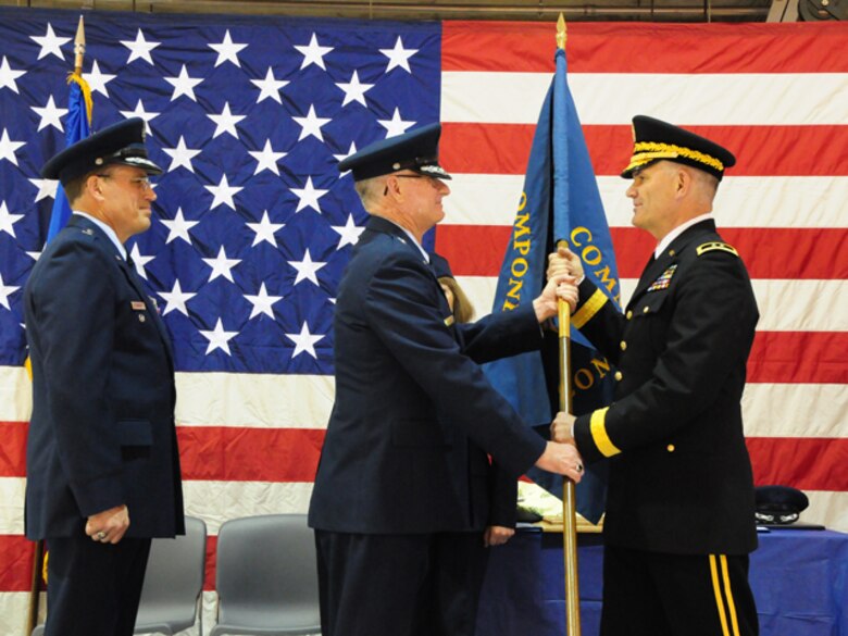 Maj. Gen. David Sprynczynatyk, the North Dakota adjutant general, right, accepts a symbolic command flag from Brig. Gen. Alan Palmer, the North Dakota National Guard Air Component Commander, and prepares to hand off the flag to newly promoted Brig. Gen. Cecil “Bud” Hensel, far left, symbolizing the assumption of command during the change of command ceremony May 1, at the North Dakota Air National Guard, Fargo, N.D.  

