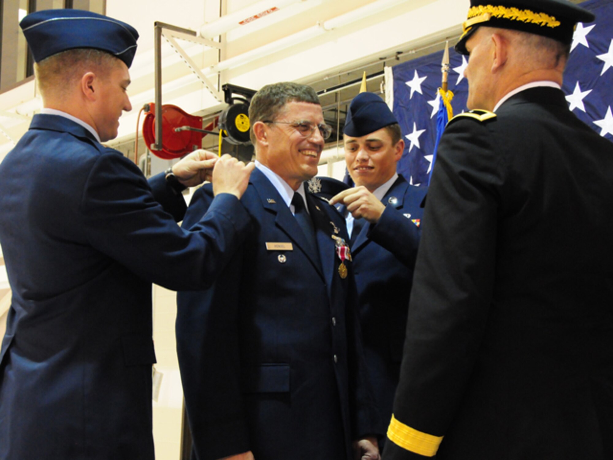 Col. Cecil  "Bud" Hensel Jr. pins on the rank of Brig. Gen. with the help of his sons Capt. Jonathon Hensel, left and Staff Sgt. Brian Hensel, as Maj. Gen. David Sprynczynatyk, the North Dakota adjutant general looks on, May 1, at the North Dakota Air National Guard, Fargo, N.D.  

