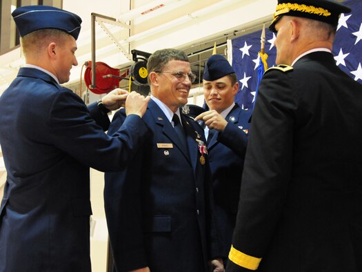 Col. Cecil  "Bud" Hensel Jr. pins on the rank of Brig. Gen. with the help of his sons Capt. Jonathon Hensel, left and Staff Sgt. Brian Hensel, as Maj. Gen. David Sprynczynatyk, the North Dakota adjutant general looks on, May 1, at the North Dakota Air National Guard, Fargo, N.D.  


