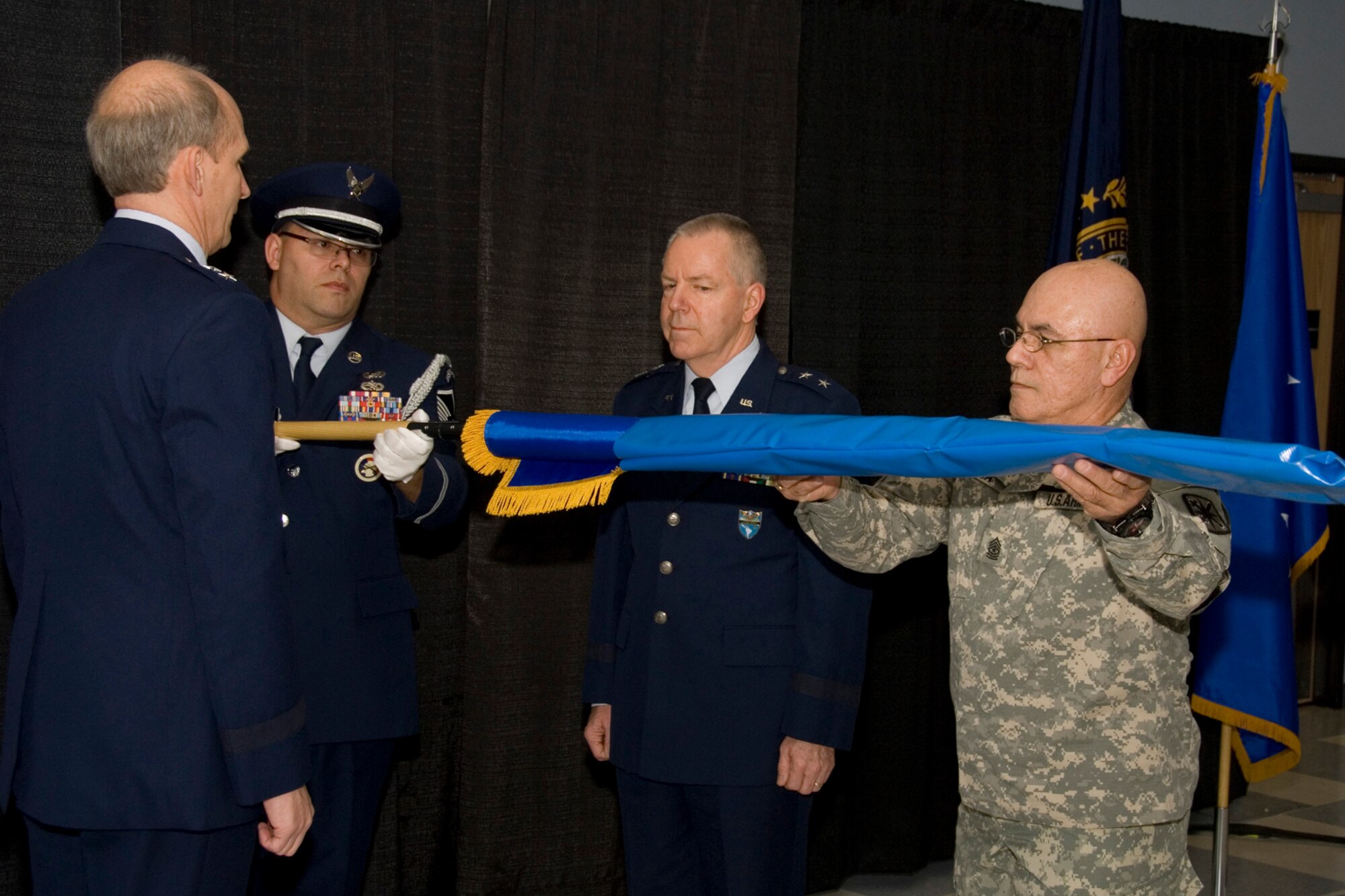 Master Sergeant William Bates and Command Sergeant Major Victor Rivera unfurl the general officer flag during the promotion ceremony for Major General Mark Sears (middle) at Pease Air National Guard Base, New Hampshire on May 1, 2010.  Sears, former Commander of the N.H.A.N.G is currently assigned as Deputy Commander for Mobilization and Reserve Affairs, United States Southern Command in Miami, Florida.  Maj. Gen. William Reddel, Adjutant General N.H. National Guard (left), looks on.  (U.S. Air Force photo/Staff Sgt. Curtis J. Lenz)