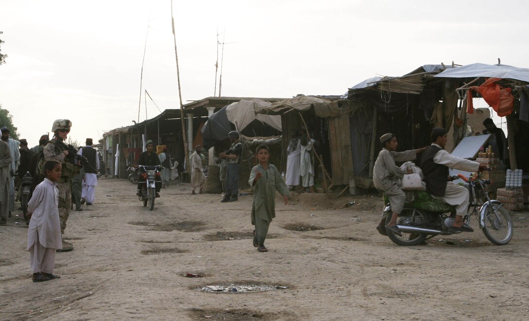 City residents pass through the Koru Chareh Bazaar in Marjah, Afghanistan, in the early evening, May 5. Since the initial fighting to take the city, residents have returned to their homes and the marketplace, the hub of the community, has reopened.
