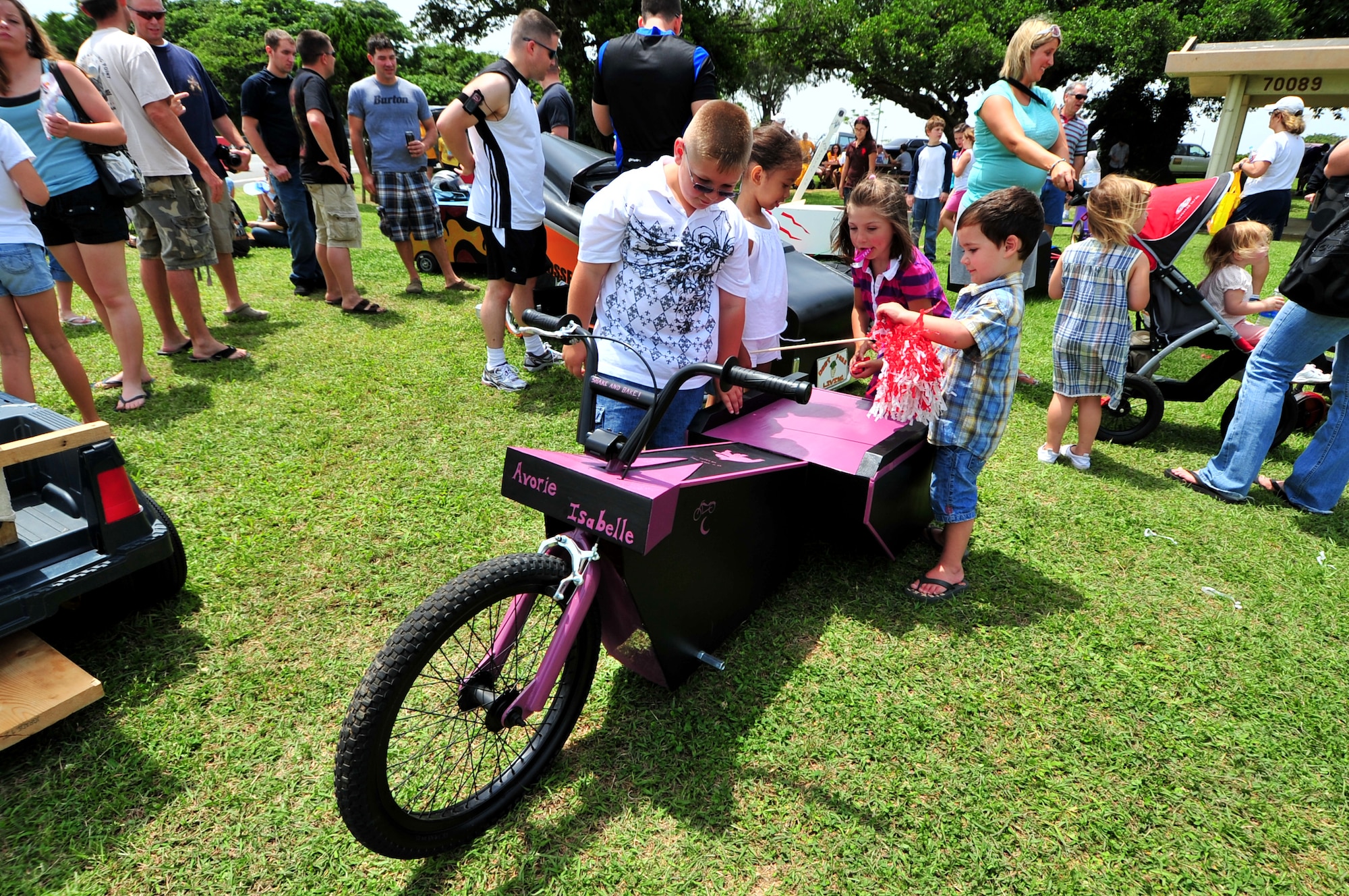 Children enjoy the day looking at soapbox derby cars during the American Red Cross Derby Day May 1 at Kadena Air Base, Japan. The event raised $5,435 for the American Red Cross. The derby car in black and purple was built by Staff Sgt. David Heaps from the 82nd Reconnaissance Squadron and placed third in the competition.(U.S. Air Force photo/Tech. Sgt. Rey Ramon)    